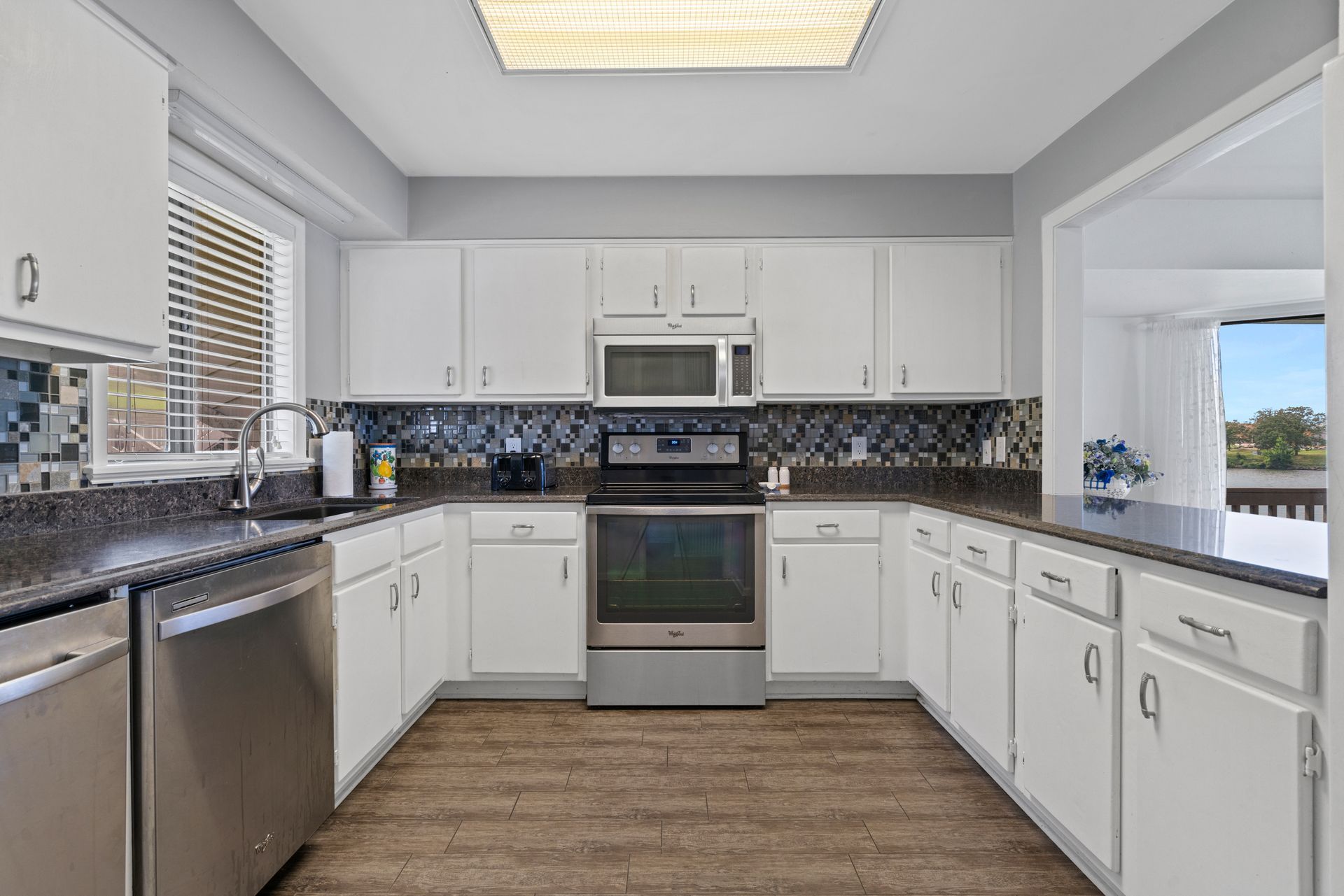 A kitchen with white cabinets and stainless steel appliances.
