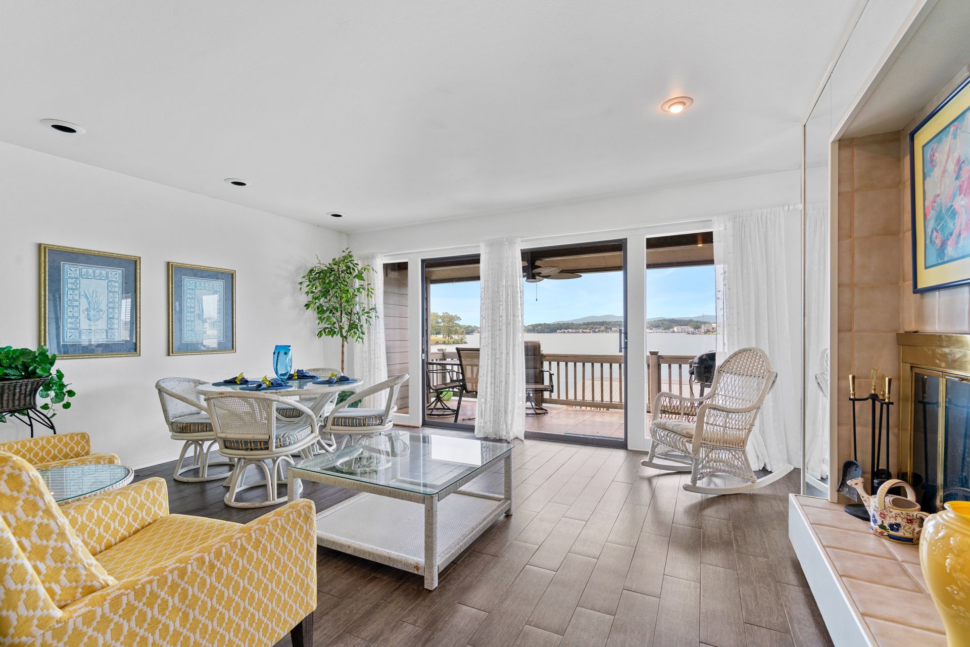 A living room filled with furniture and a fireplace with a view of the ocean.