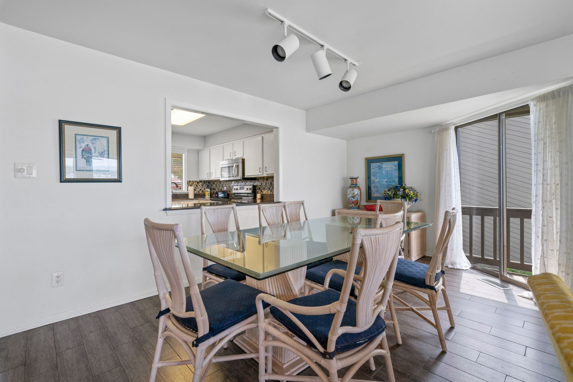 A dining room with a glass table and chairs in a house.