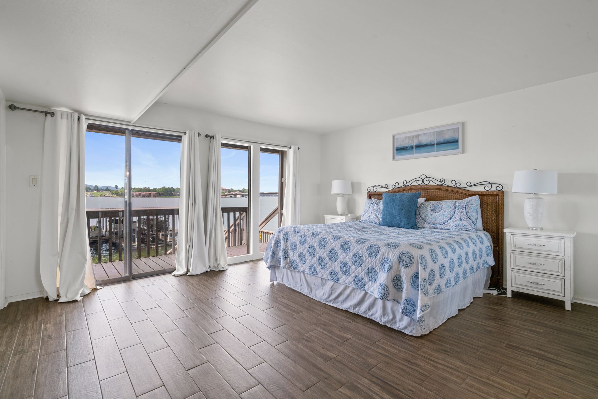 A large bedroom with a king size bed and a balcony.