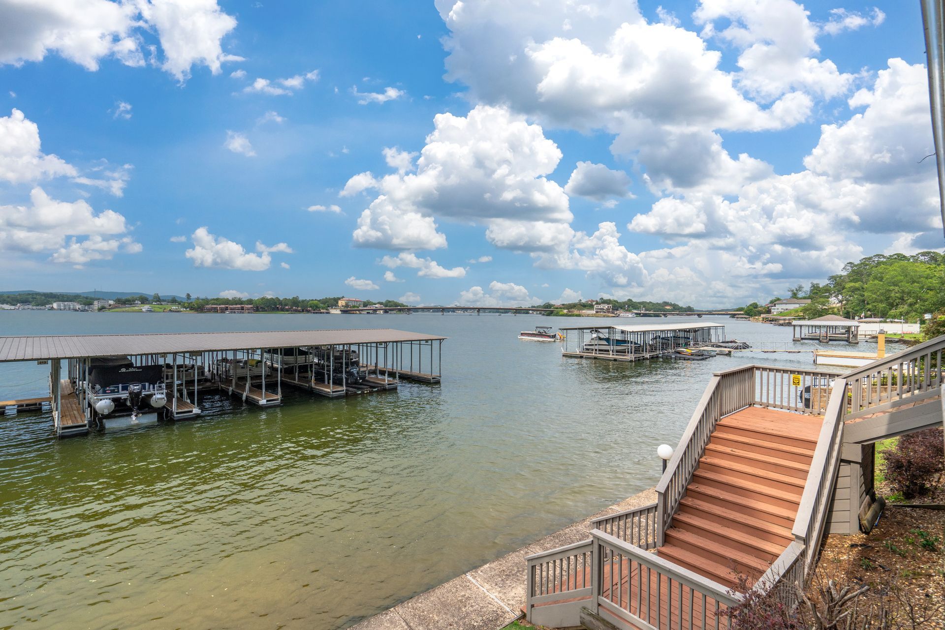 A view of a lake with boats docked and stairs leading up to it.