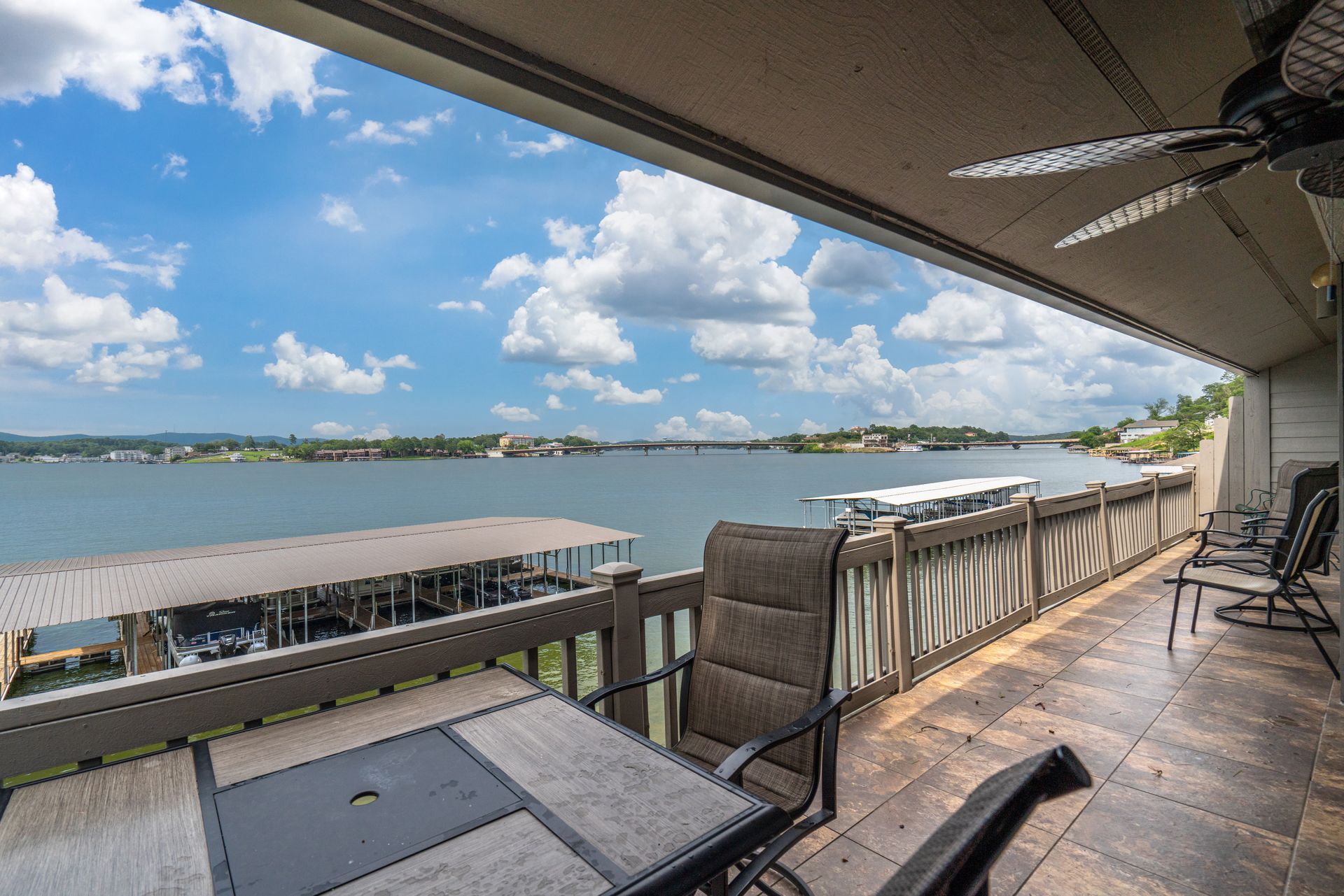 A balcony with a table and chairs overlooking a body of water.