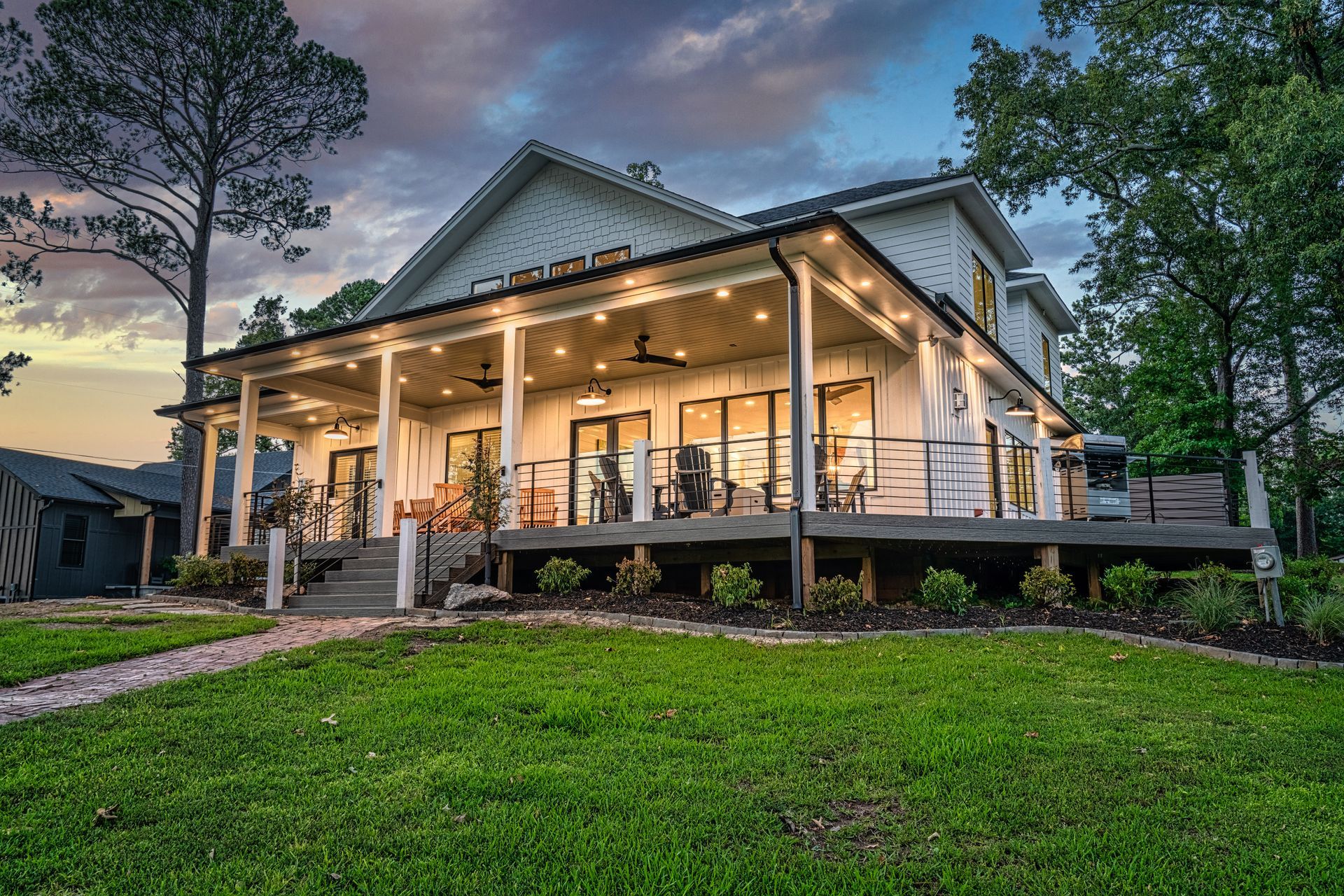 A large white house with a large porch and a large deck.