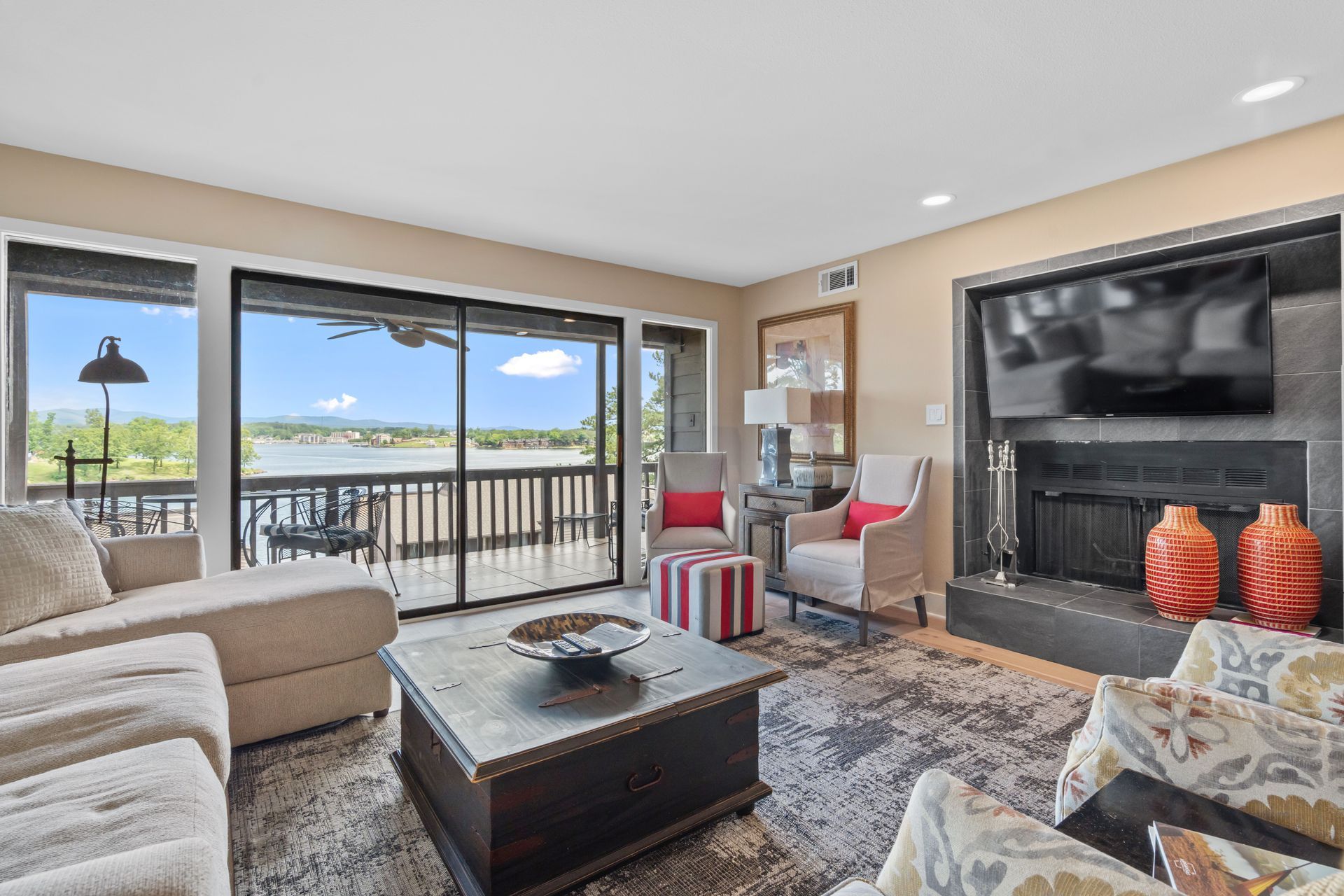 A living room with a fireplace , couch , chairs , coffee table and television.