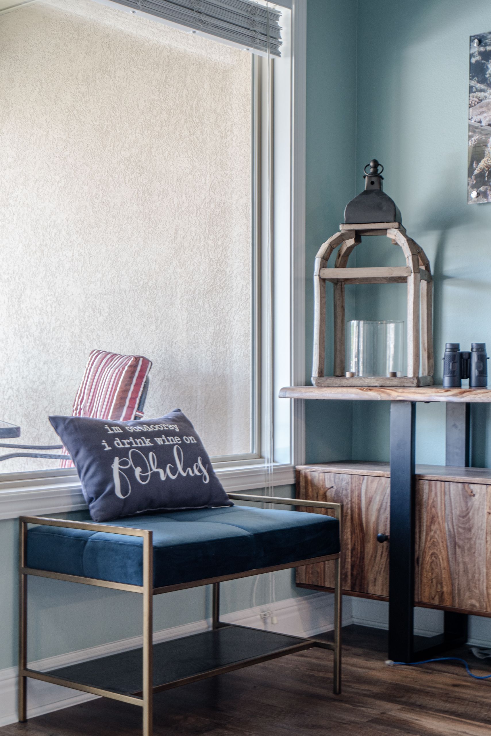 A bench with a pillow on it is sitting in front of a window.