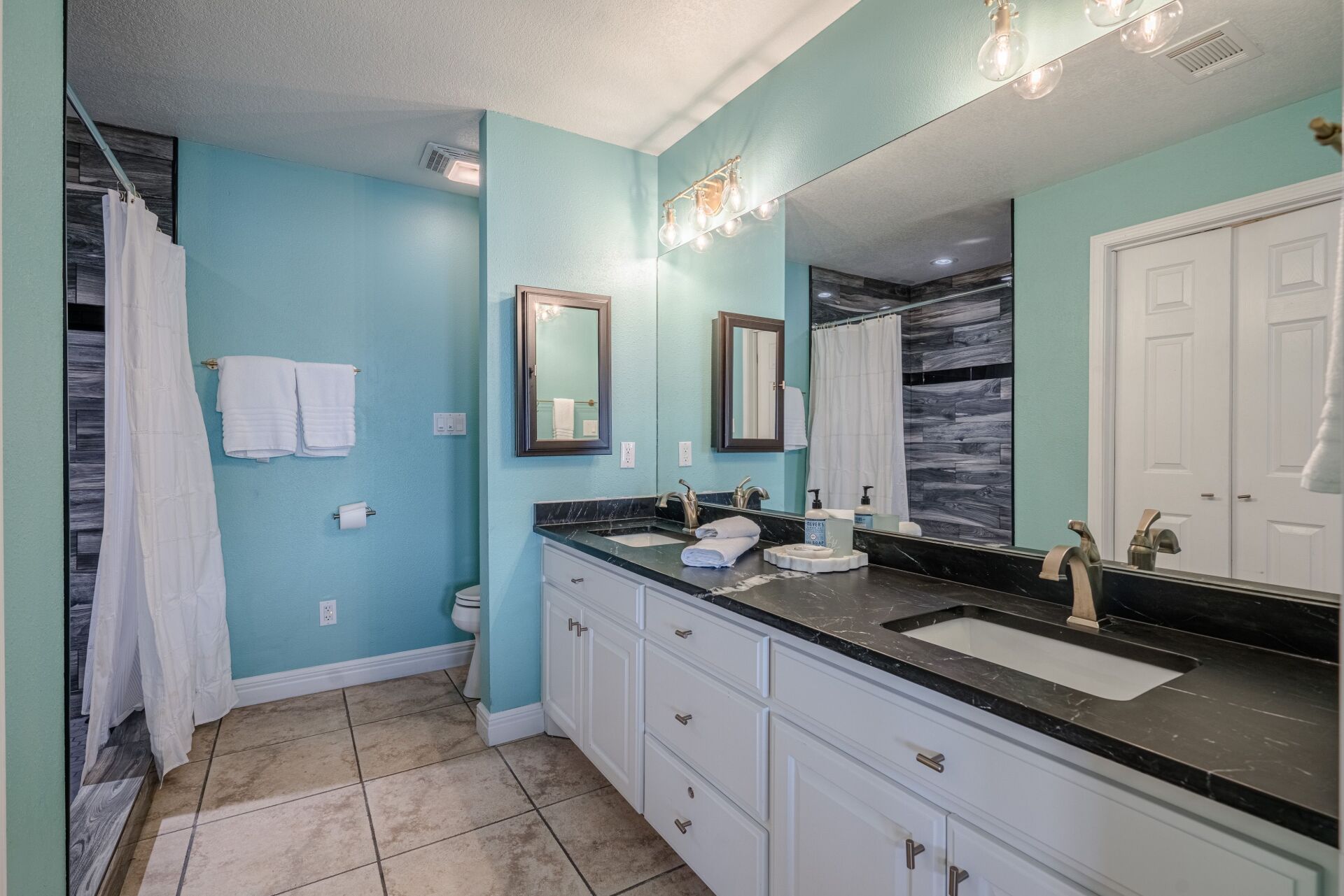 A bathroom with two sinks and a large mirror.