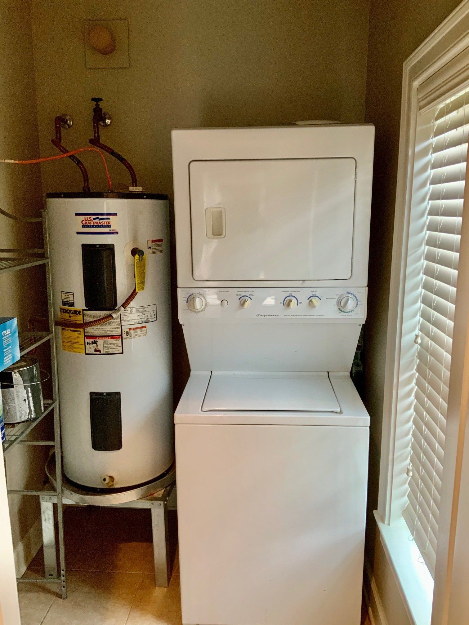 A washer and dryer are stacked on top of each other in a laundry room.