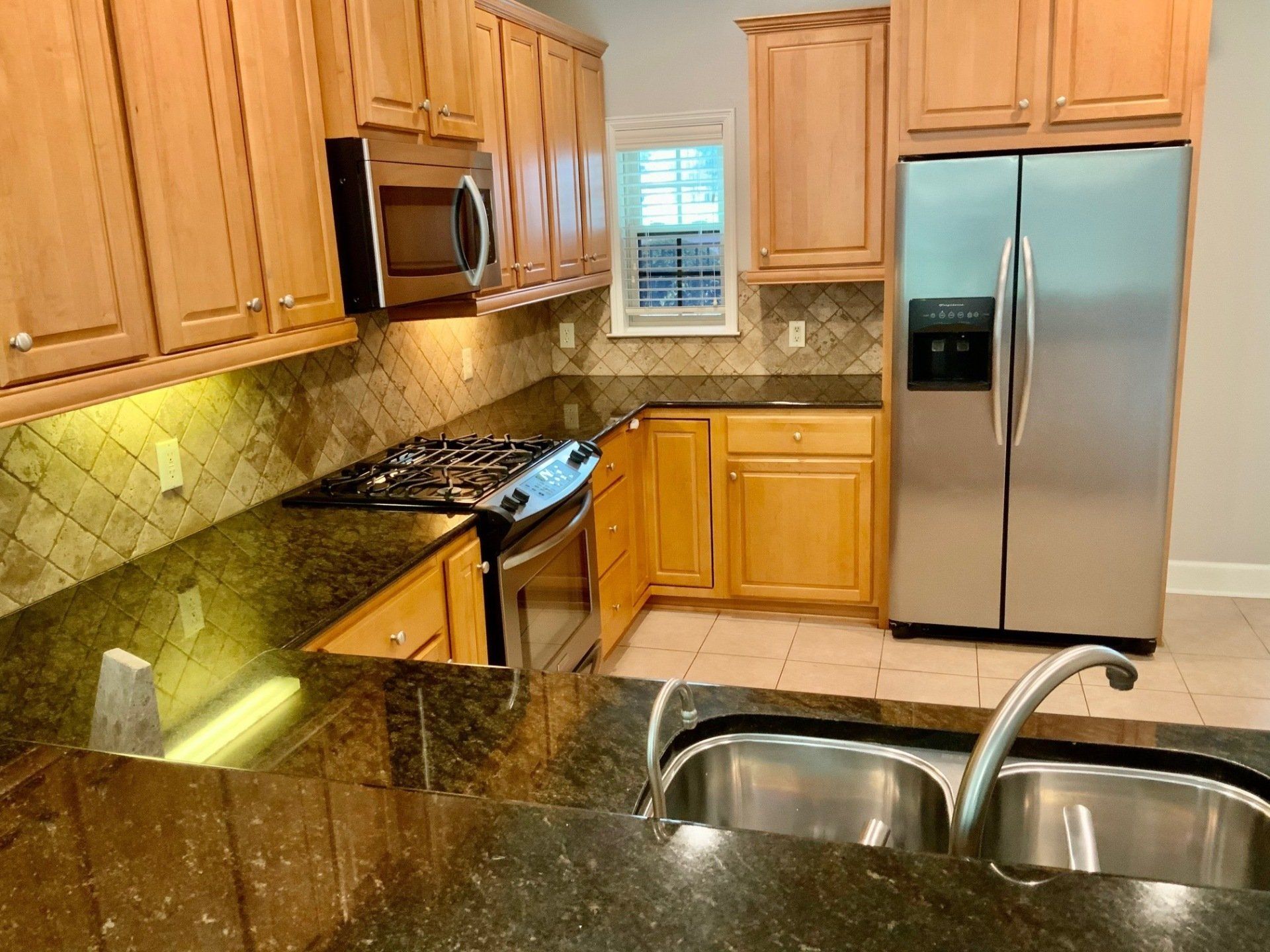 A kitchen with stainless steel appliances and wooden cabinets