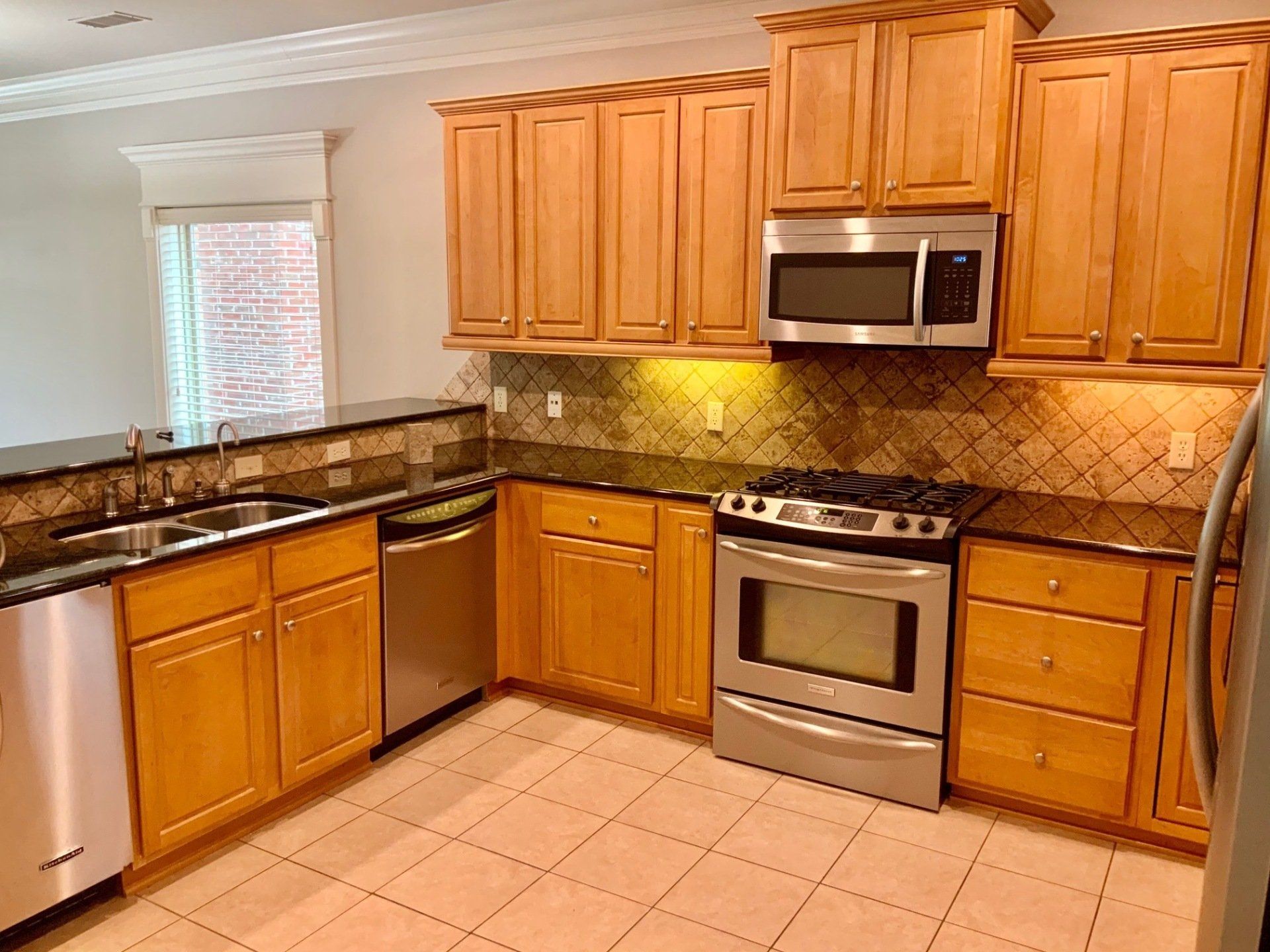 A kitchen with wooden cabinets and stainless steel appliances