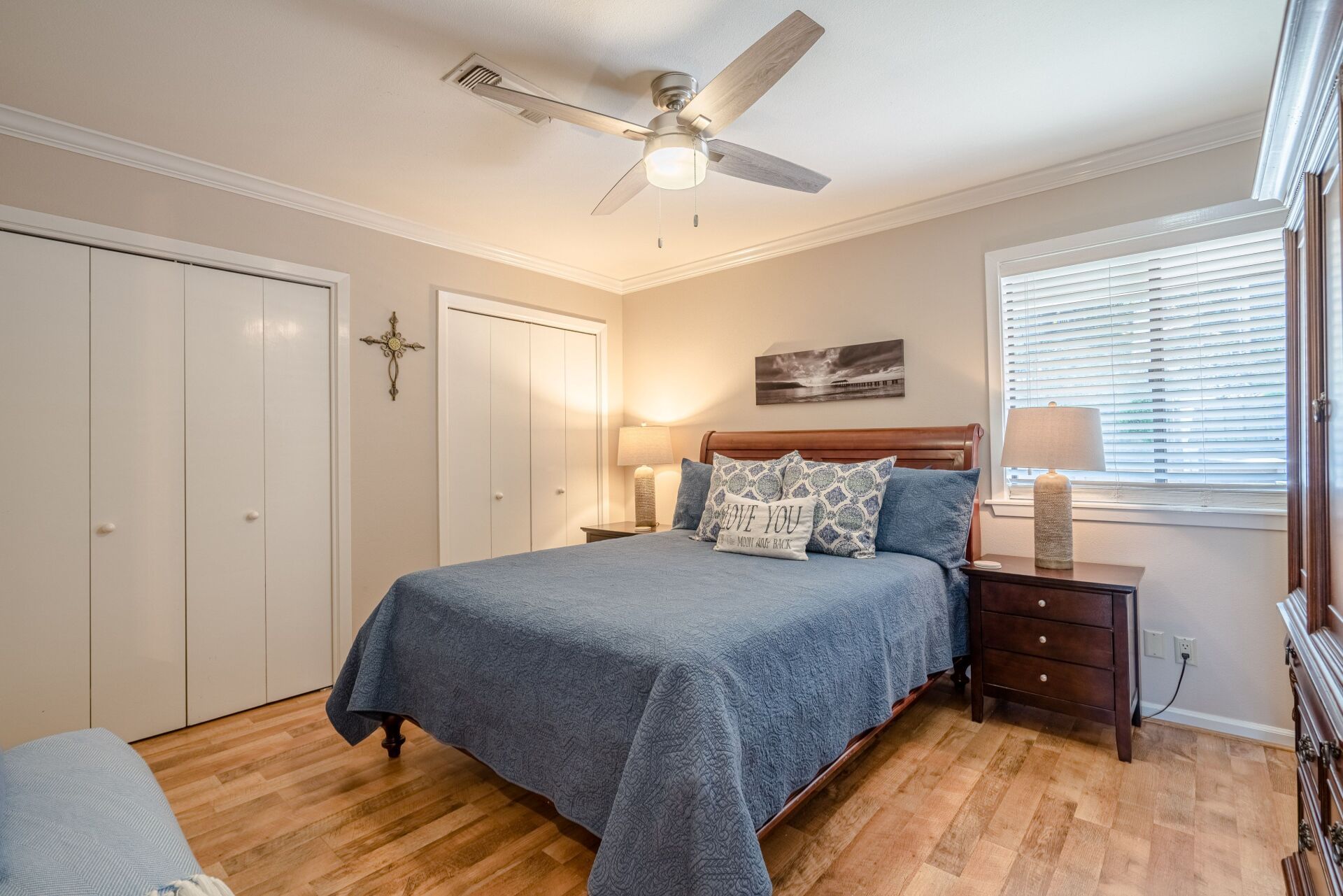 A bedroom with a king size bed and a ceiling fan.