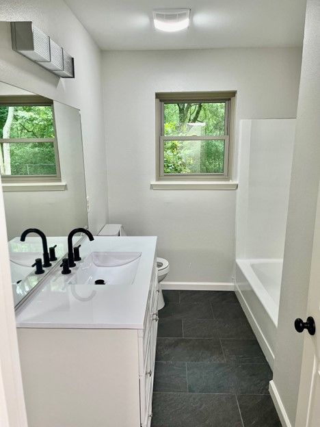 A bathroom with a sink , toilet , and bathtub.