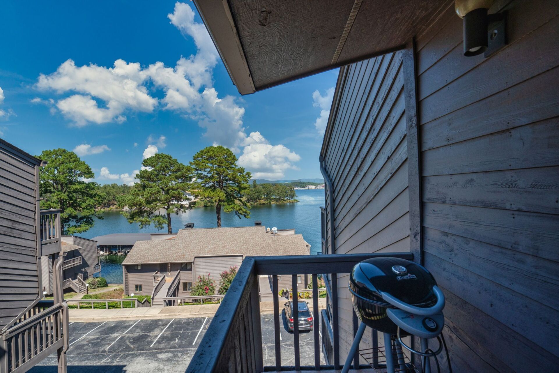A view of a lake from a balcony with a grill on it