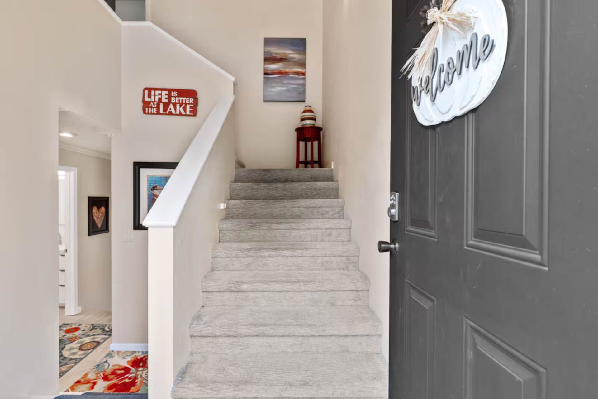 Entryway with stairs leading up, grey door with