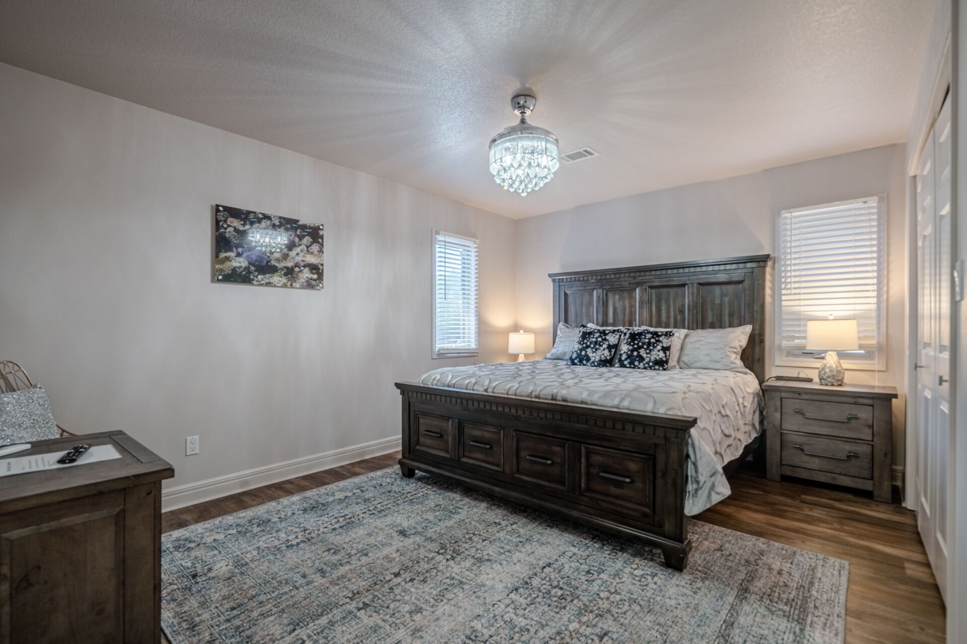 A bedroom with a king size bed , nightstands , and a ceiling fan.