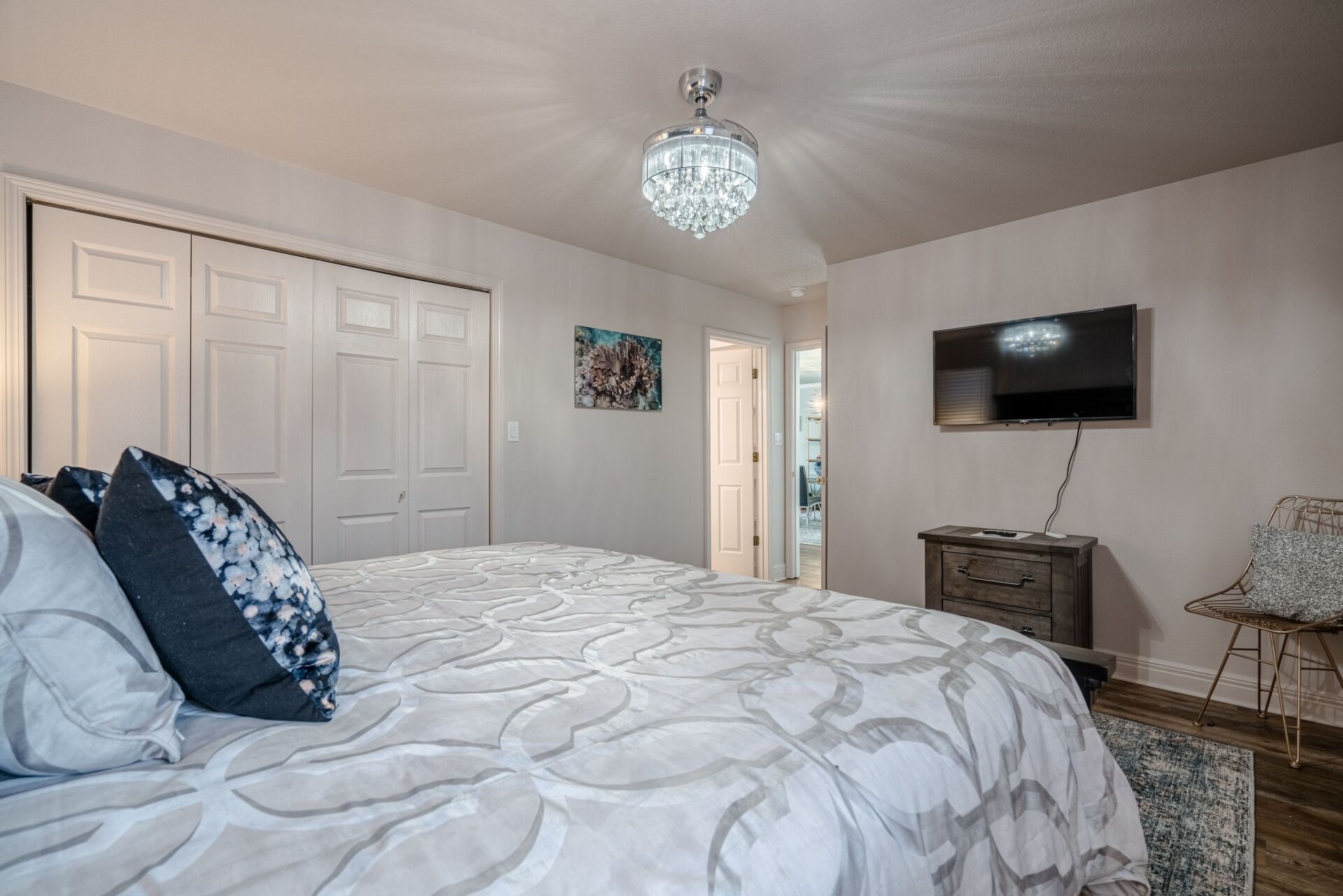 A bedroom with a king size bed and a flat screen tv.