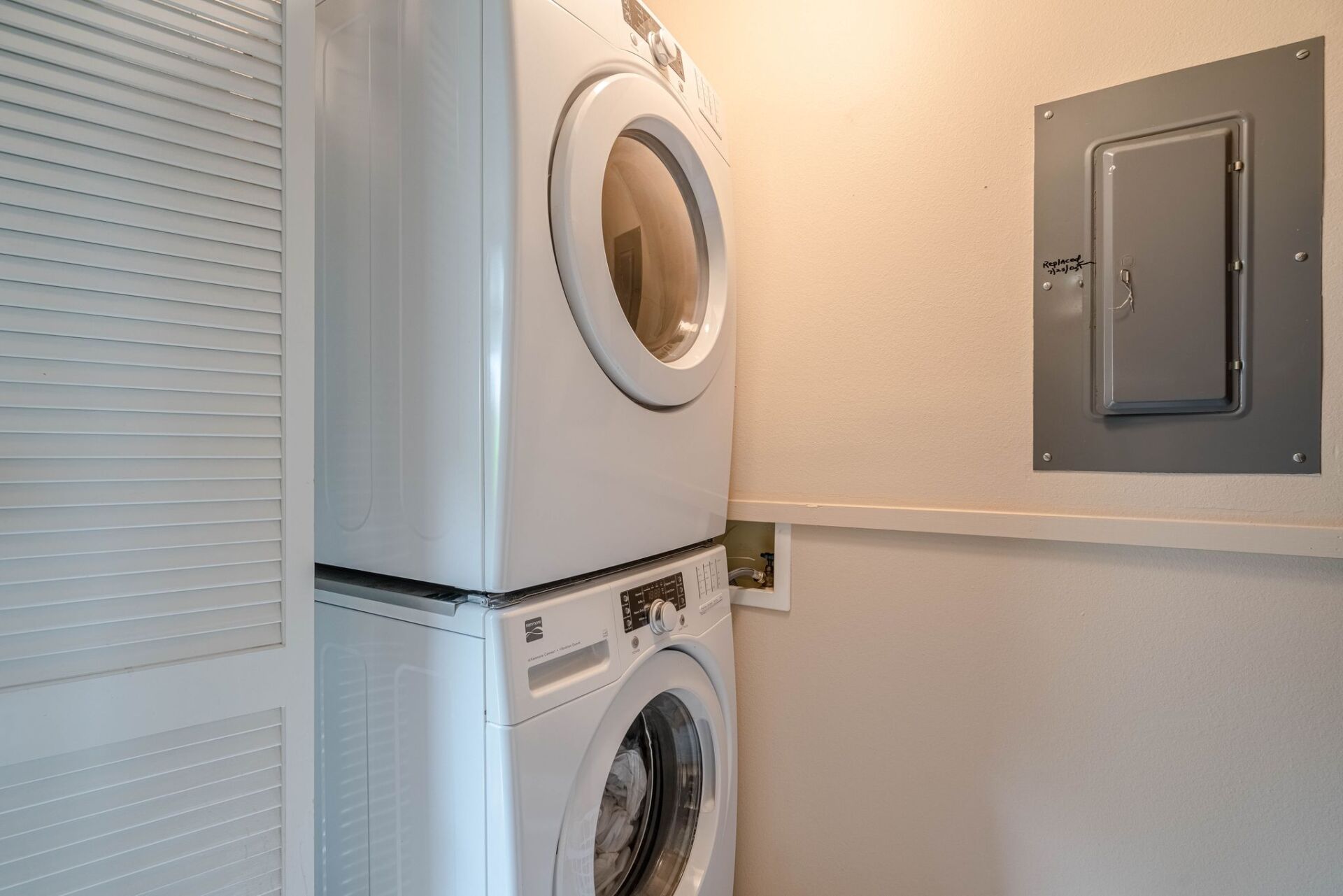 A washer and dryer are stacked on top of each other in a laundry room.