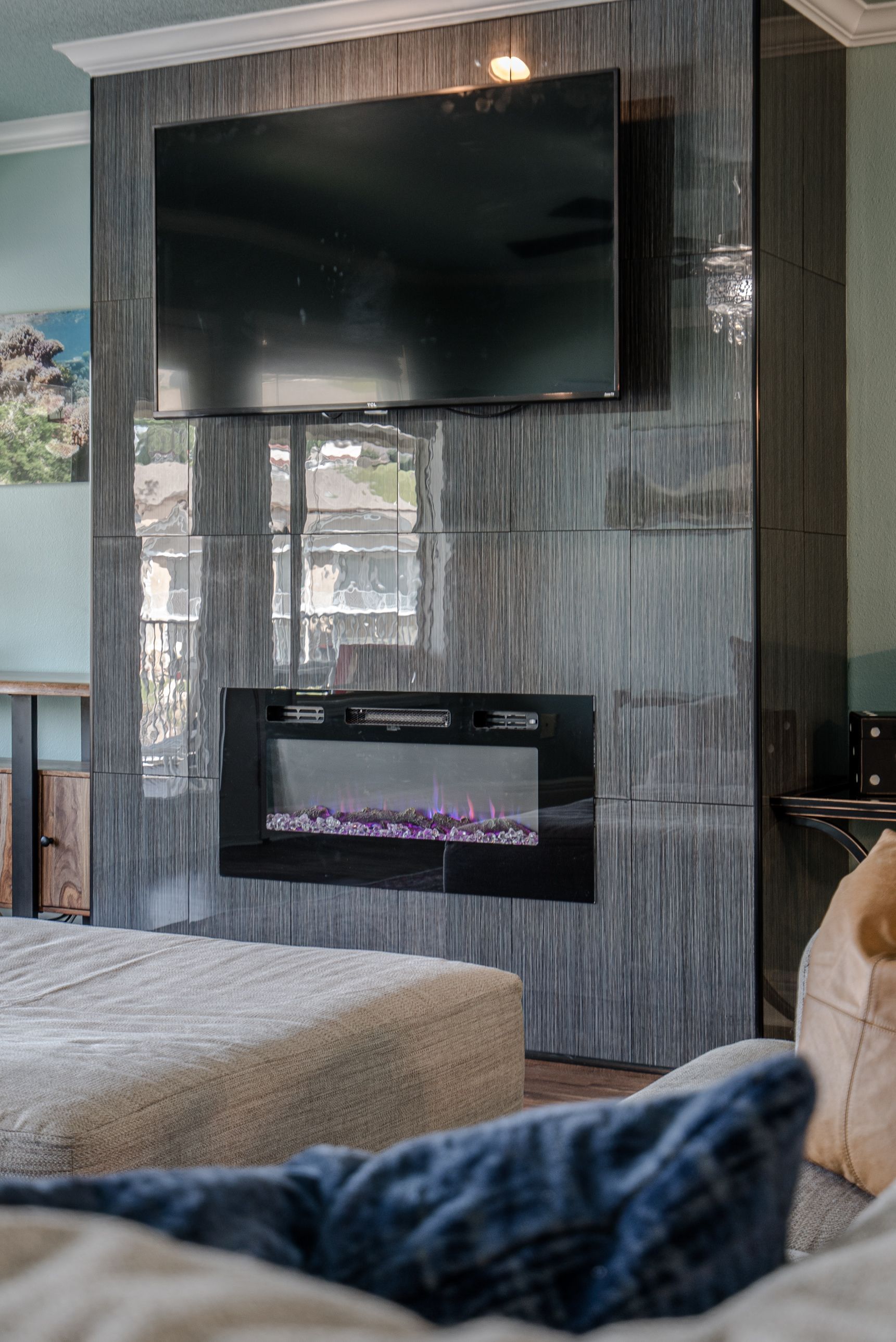 A living room with a fireplace and a flat screen tv on the wall.