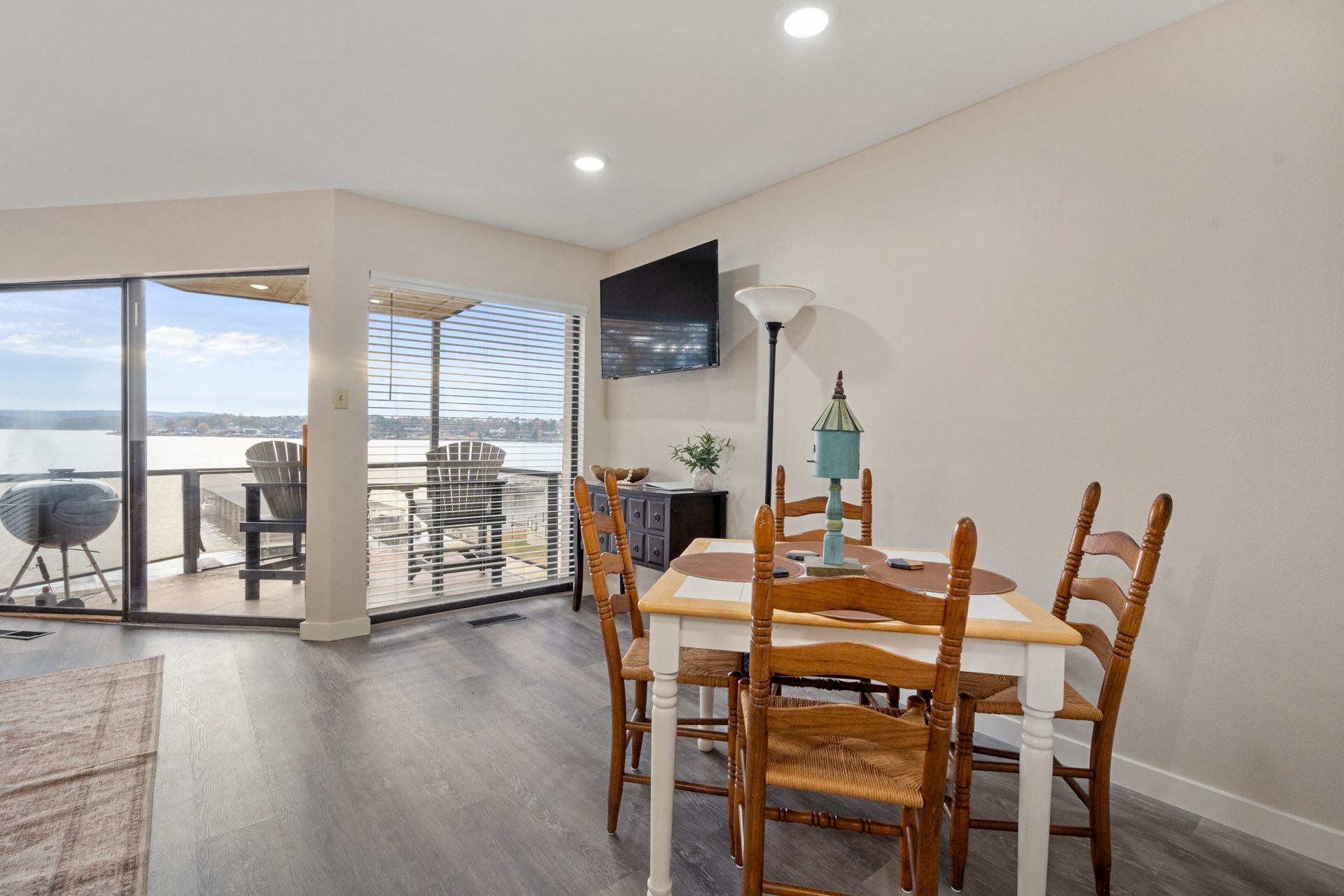 A dining room with a table and chairs and a television.