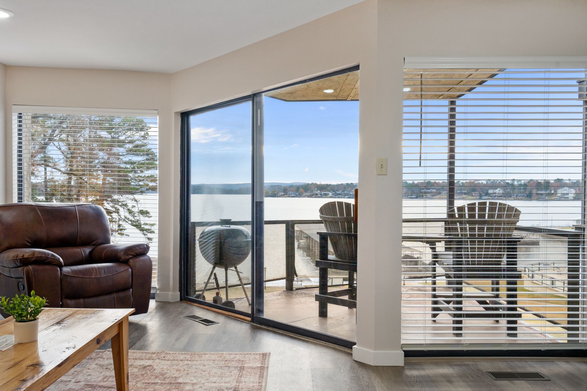 A living room with a large window and a view of a lake.