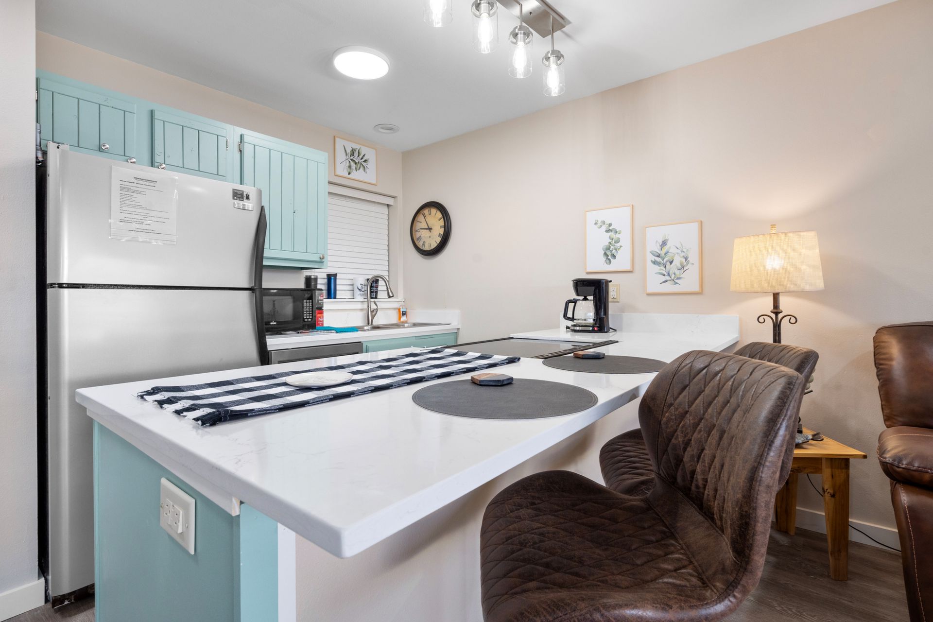 A kitchen with a table and chairs and a refrigerator.