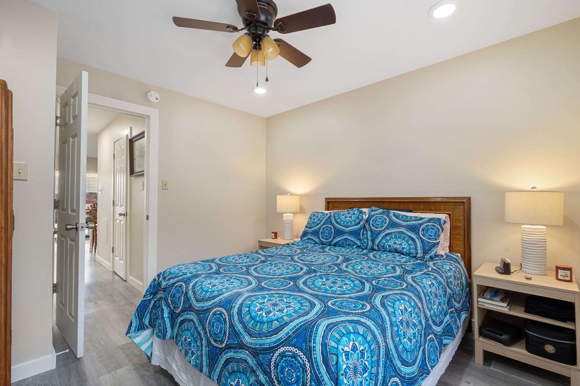 A bedroom with a king size bed and a ceiling fan.