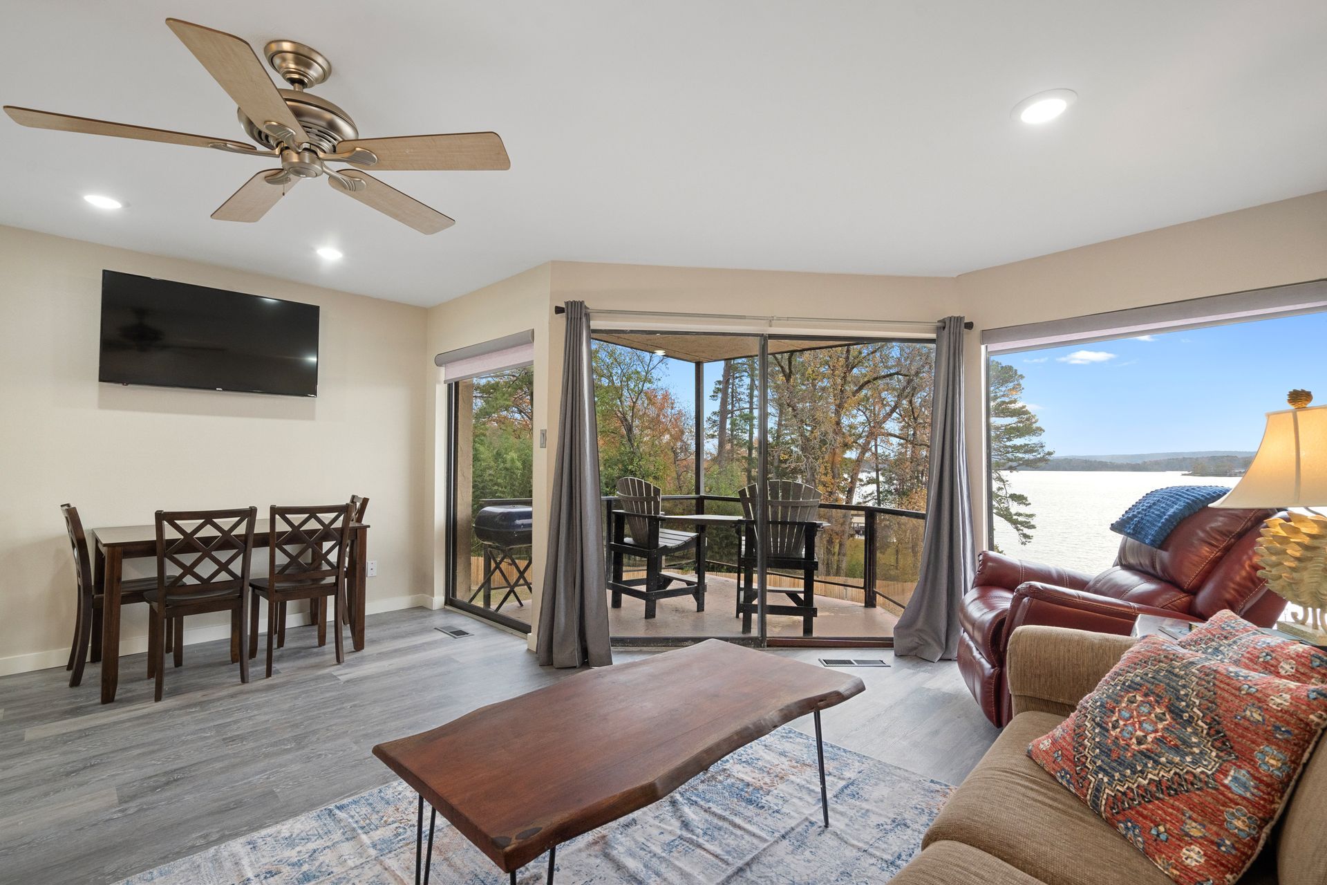 A living room with a couch , table , chairs and a ceiling fan.