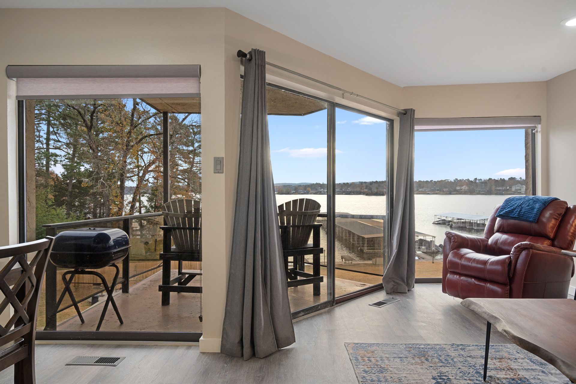 A living room with a view of a lake and a sliding glass door.