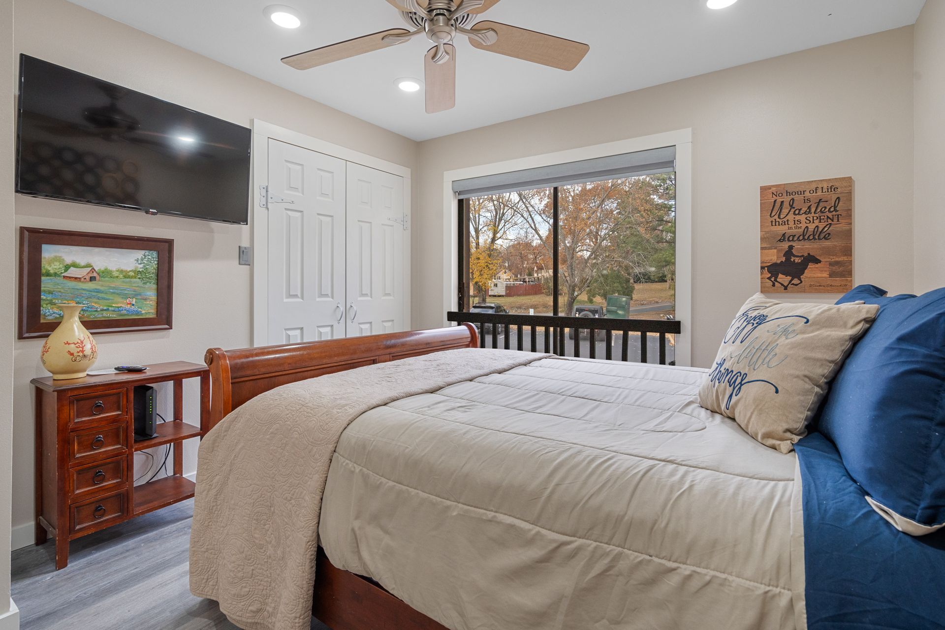 A bedroom with a king size bed , television , and ceiling fan.