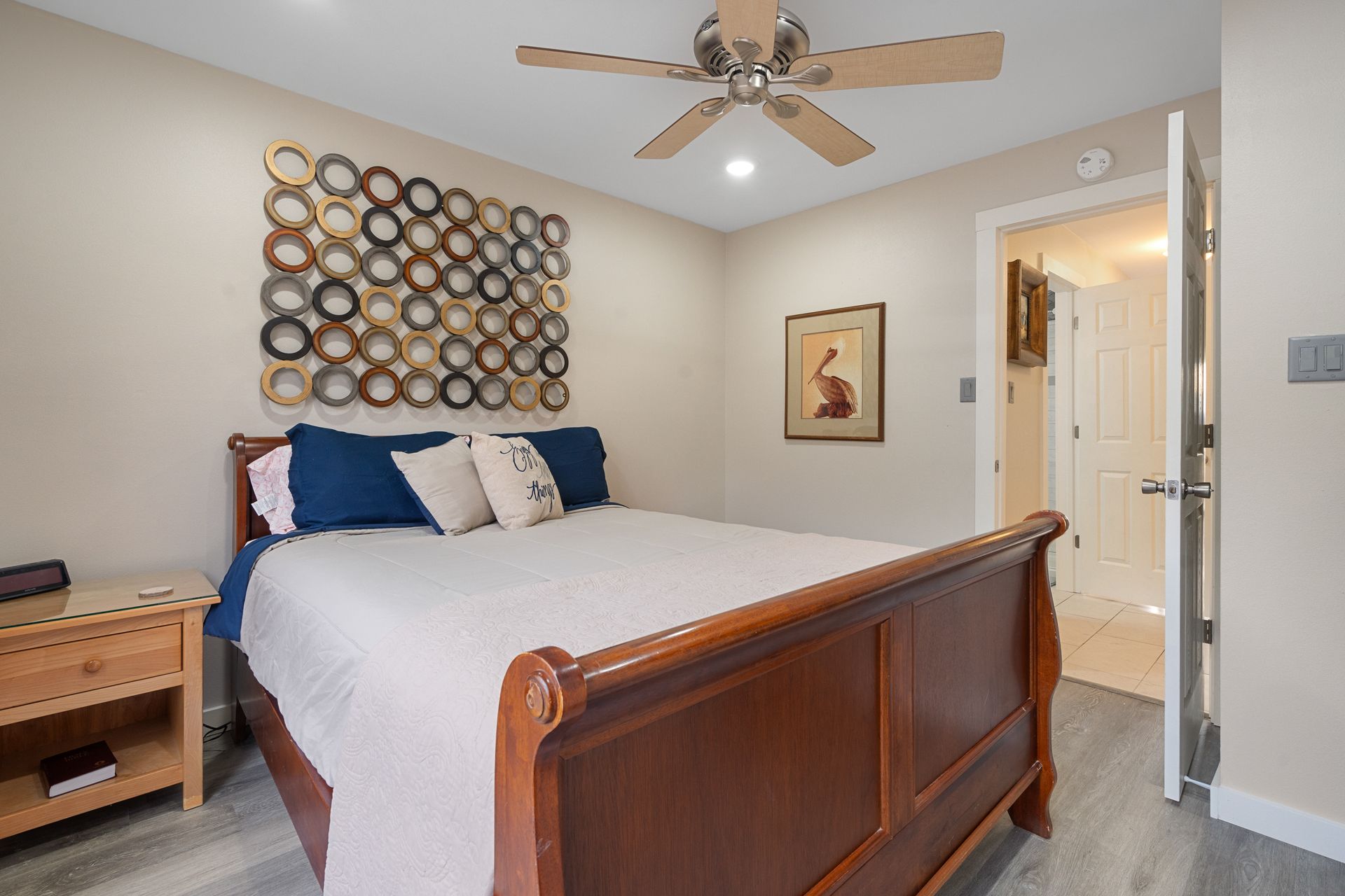 A bedroom with a king size bed and a ceiling fan.