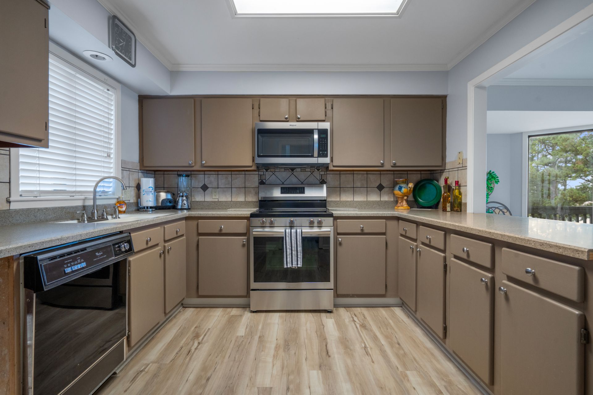 A kitchen with stainless steel appliances and brown cabinets.