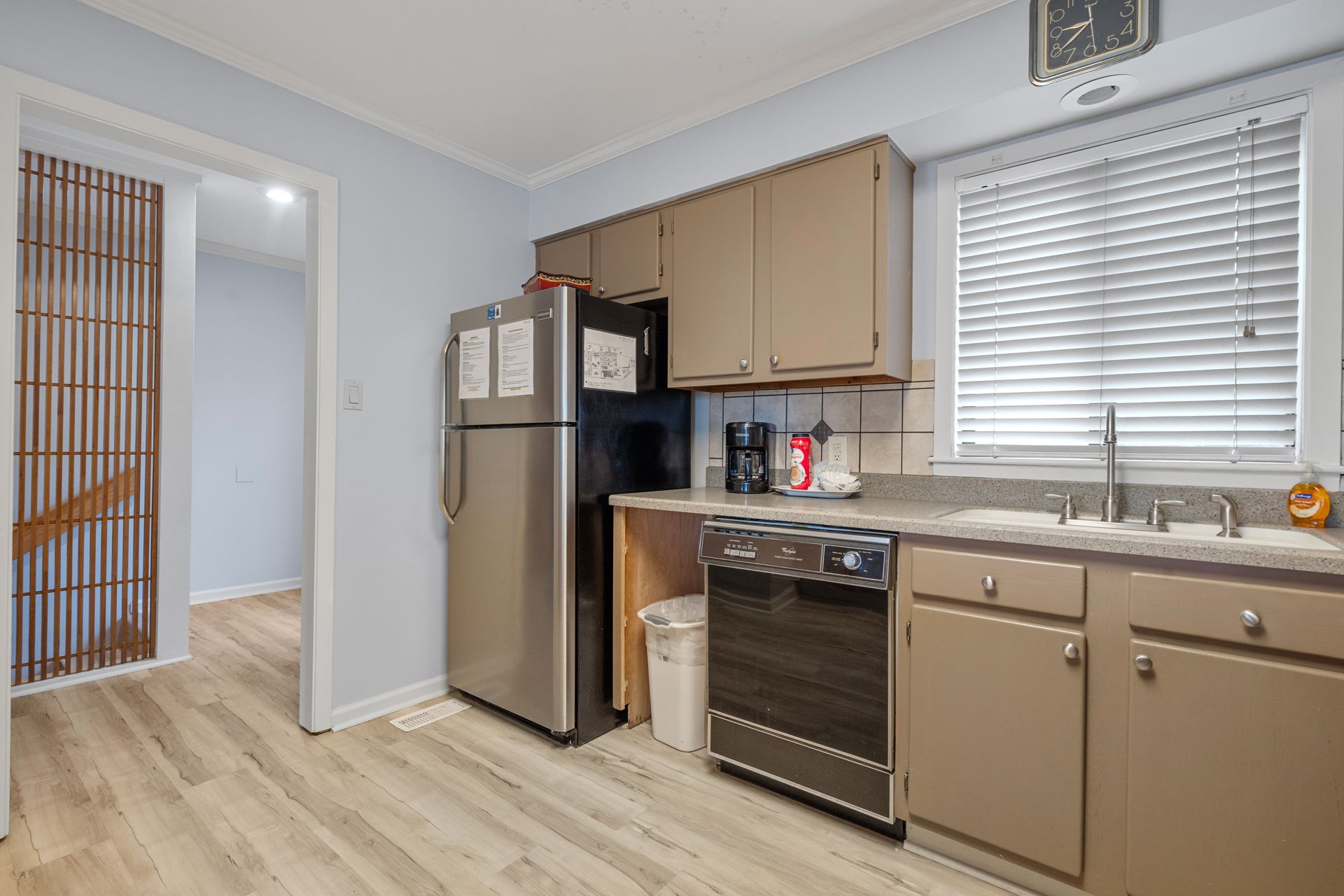 A kitchen with stainless steel appliances and brown cabinets.