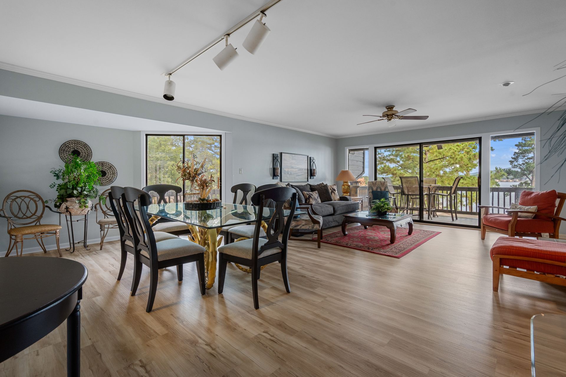 A living room with a dining table and chairs and a balcony.