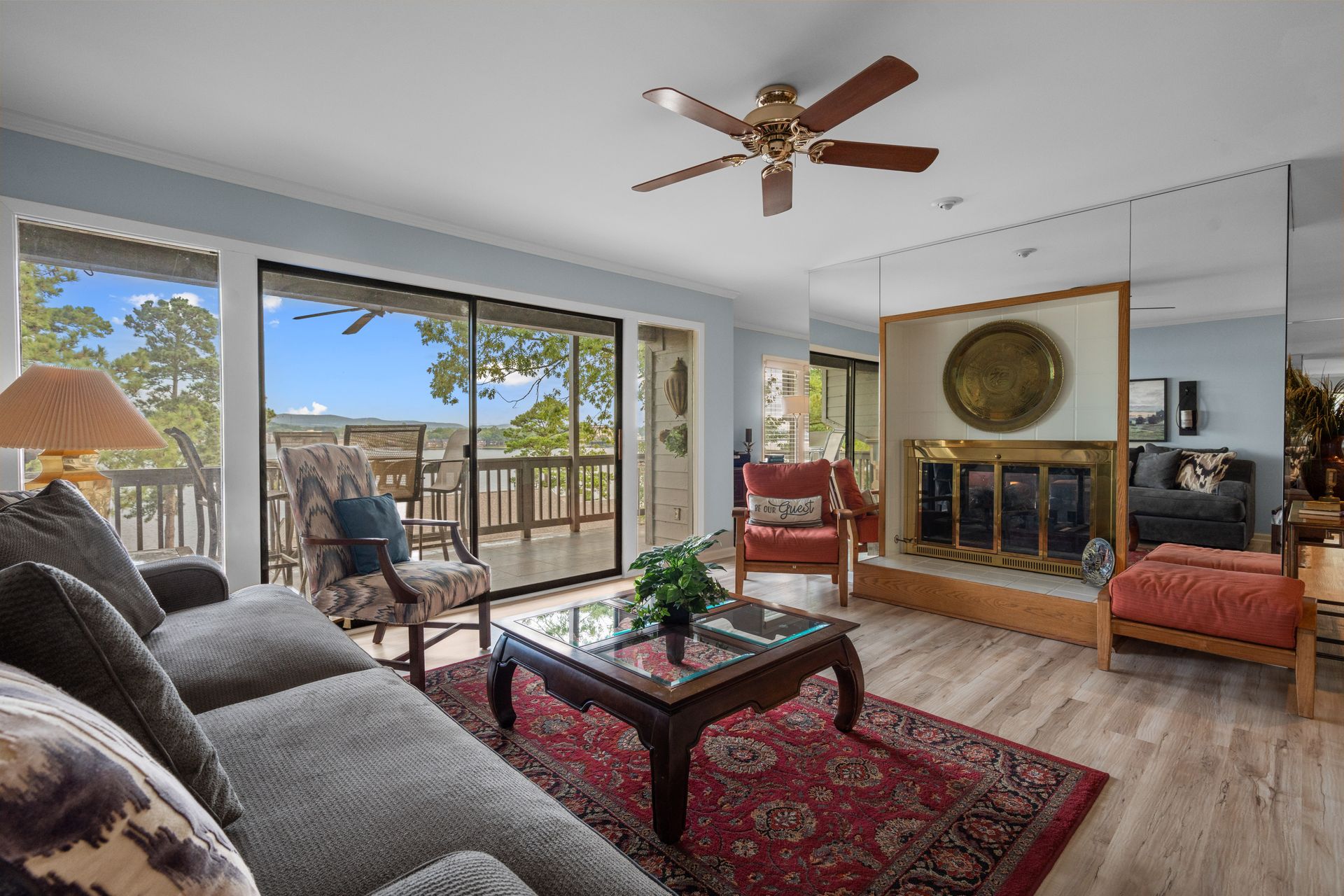 A living room with a couch , chair , coffee table and ceiling fan.