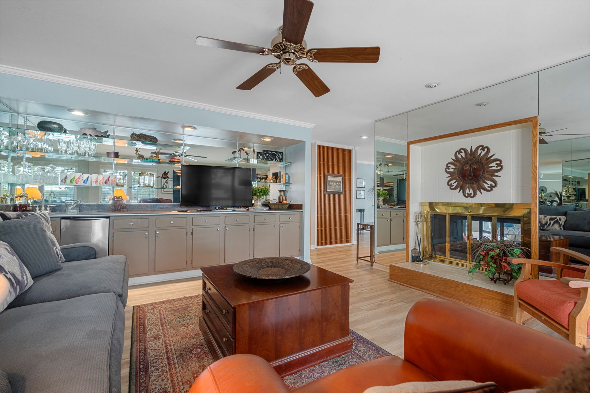 A living room with a ceiling fan and a fireplace.