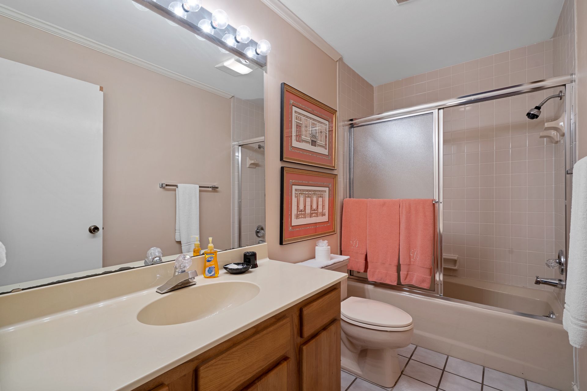 A bathroom with a sink , toilet , bathtub and mirror.