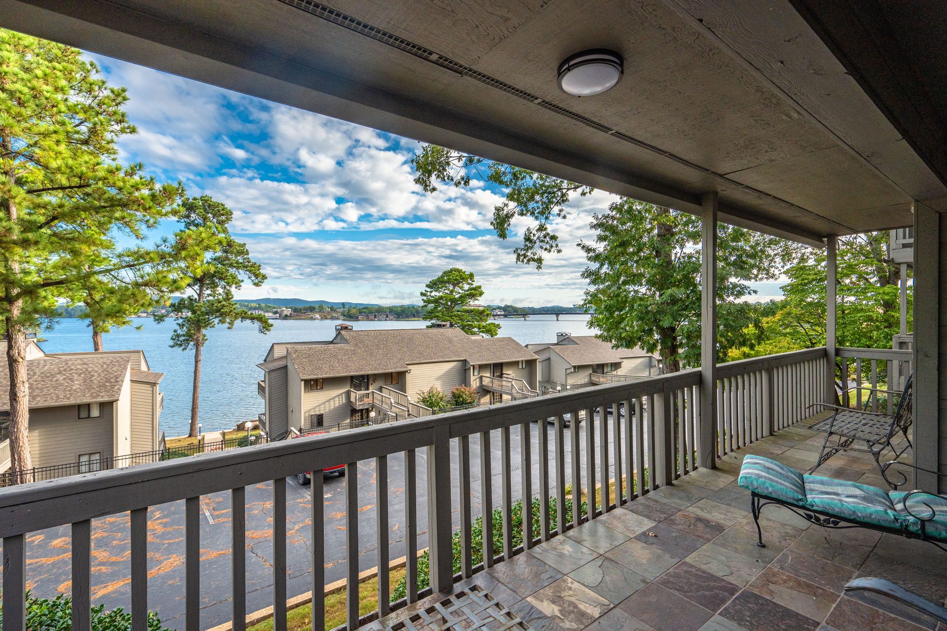 A balcony with a view of a lake and trees