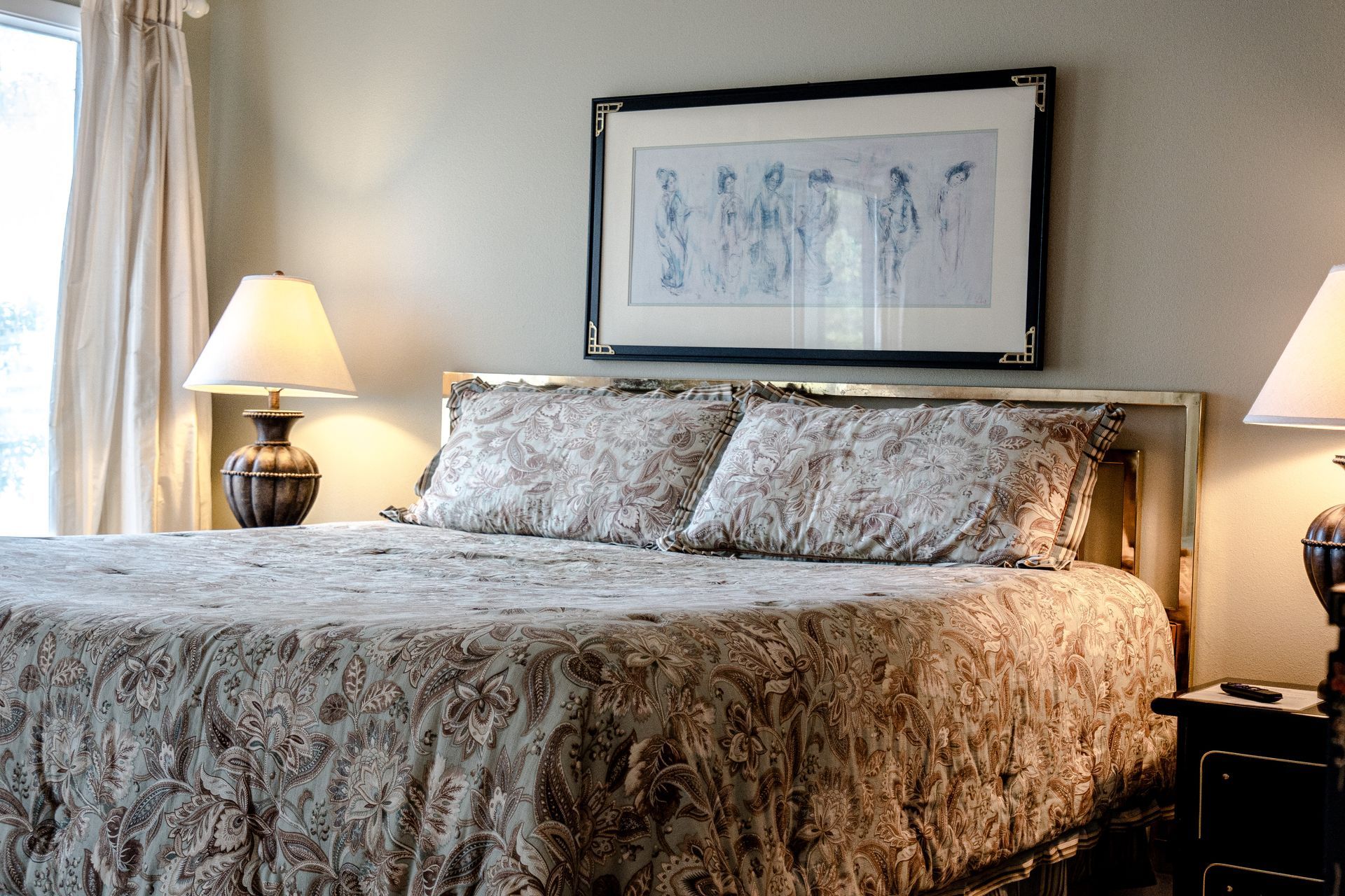 A bedroom with a king size bed and two lamps