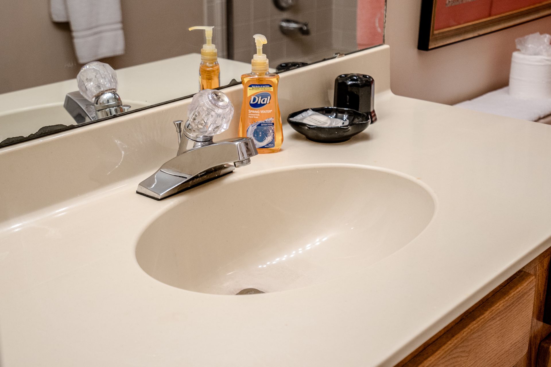 A bathroom sink with a mirror and soap dispensers on the counter.