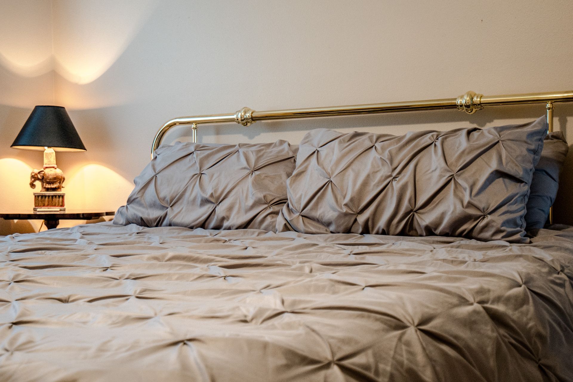 A bed with pillows and a lamp in a bedroom