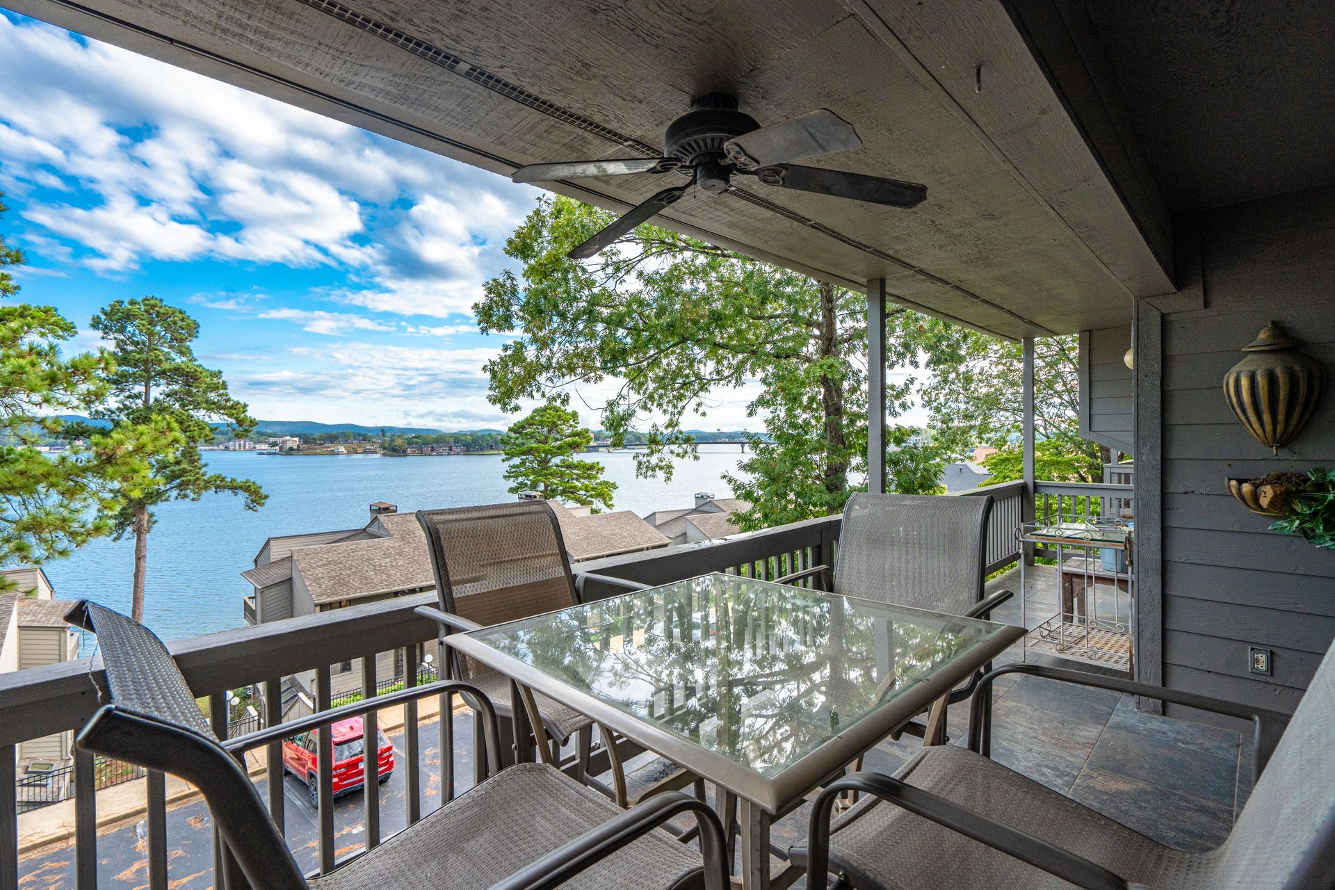 A balcony with a table and chairs overlooking a lake.