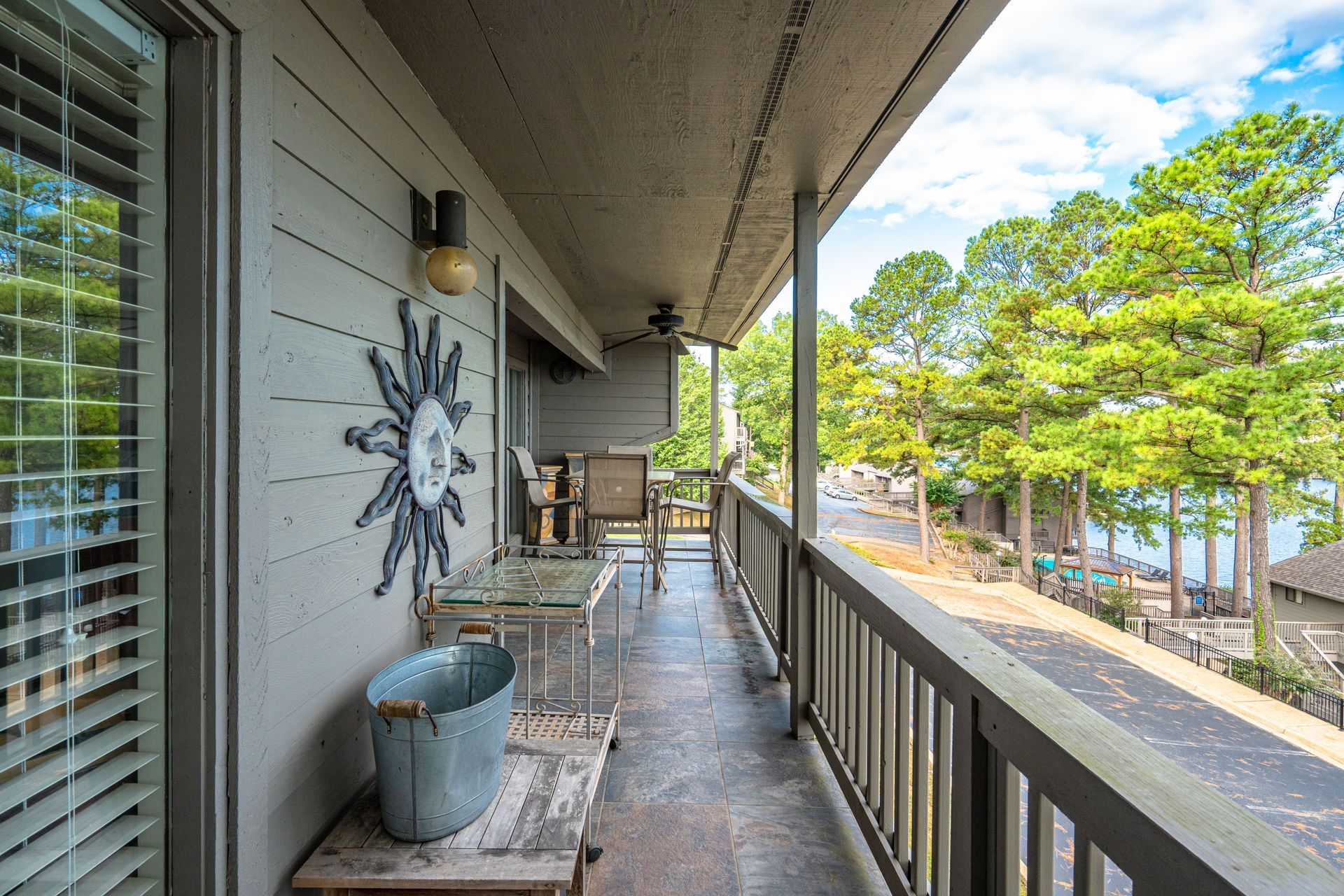 A balcony with a view of a lake and trees.