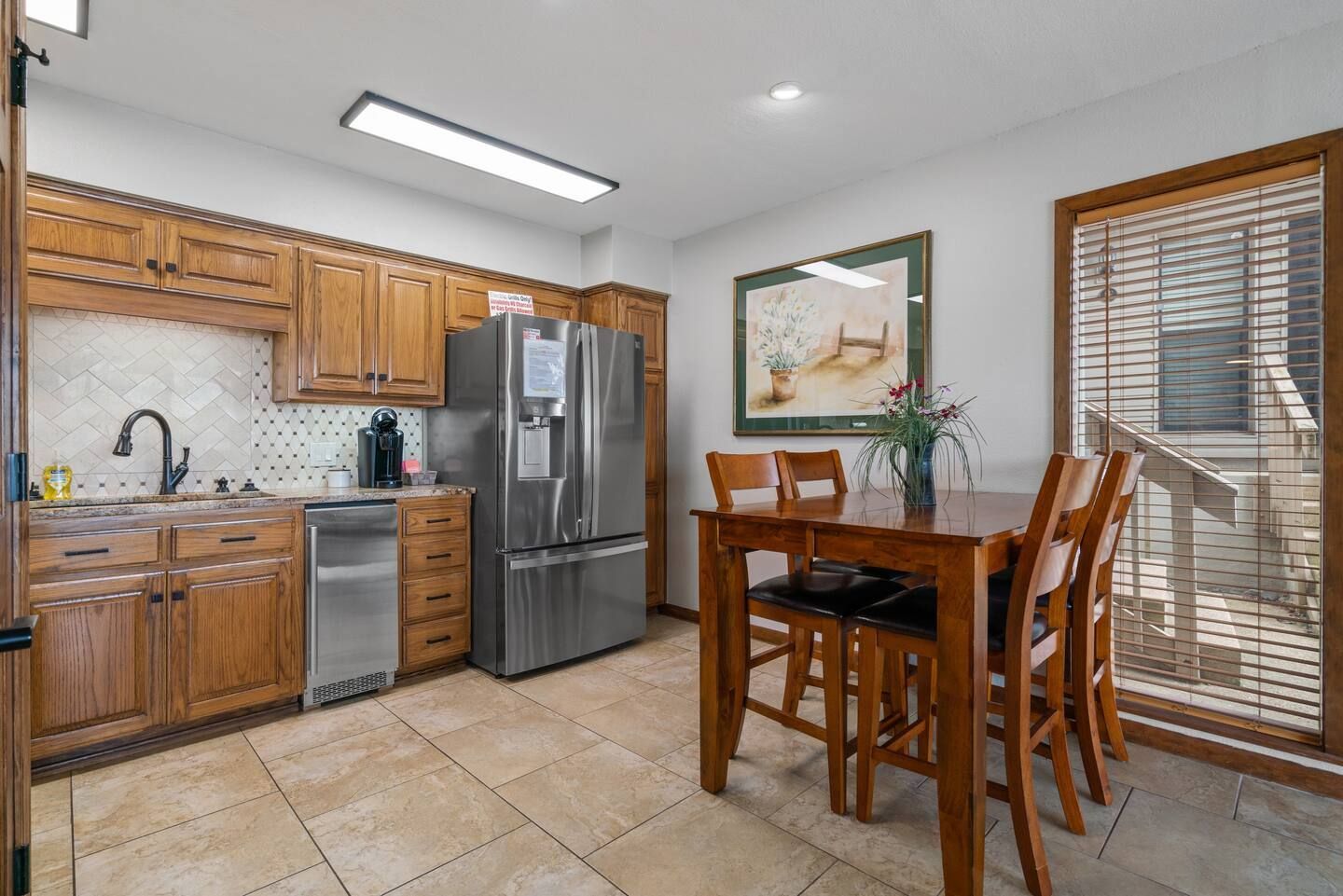 A kitchen with a table and chairs and a refrigerator.