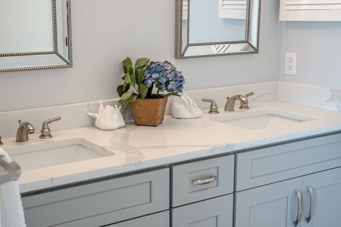 A bathroom with two sinks and two mirrors.