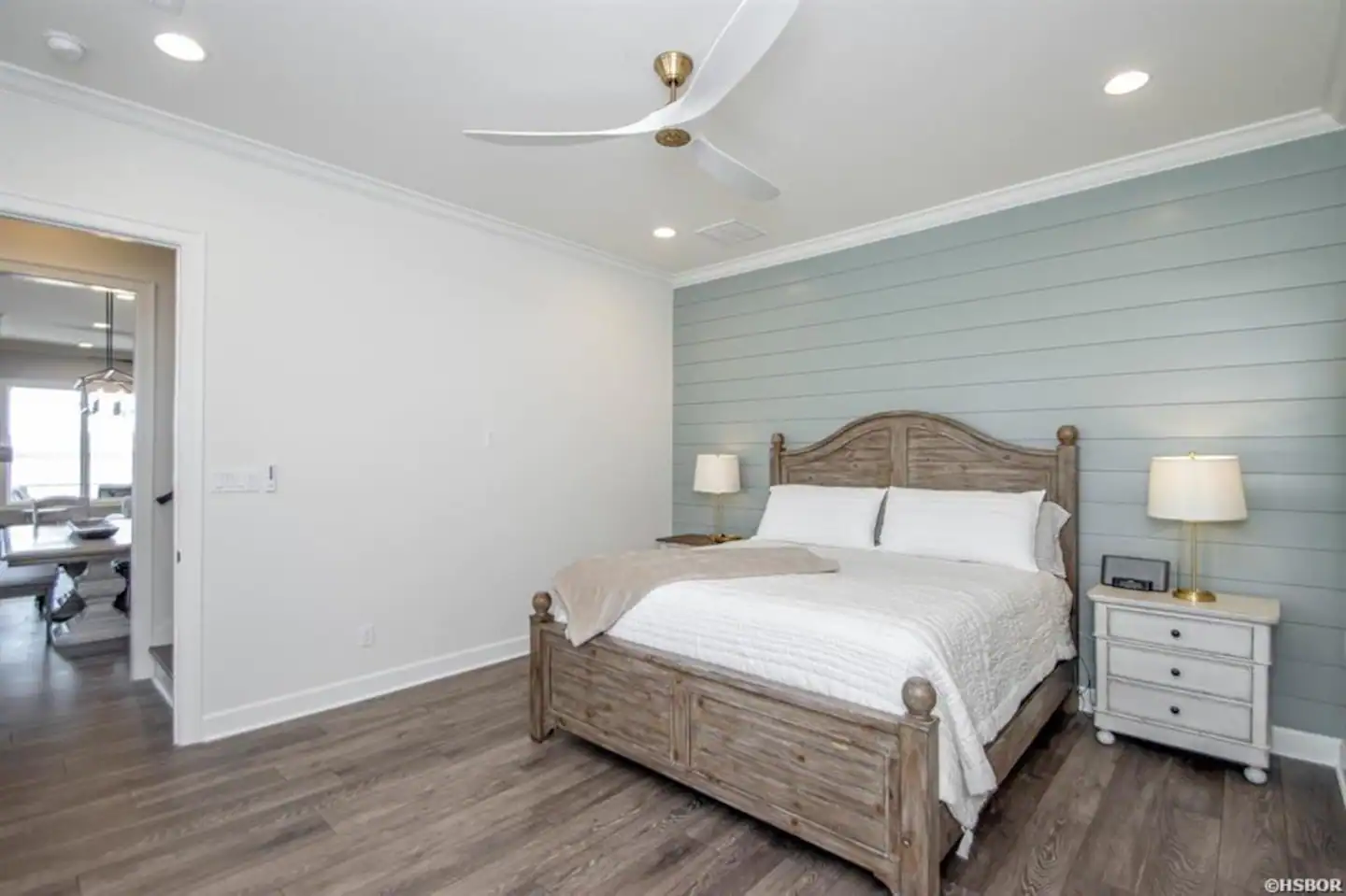 A bedroom with a king size bed and a ceiling fan.