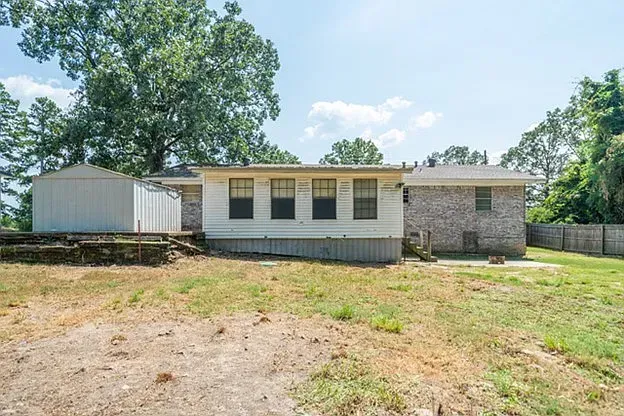 A mobile home is sitting in the middle of a grassy field.