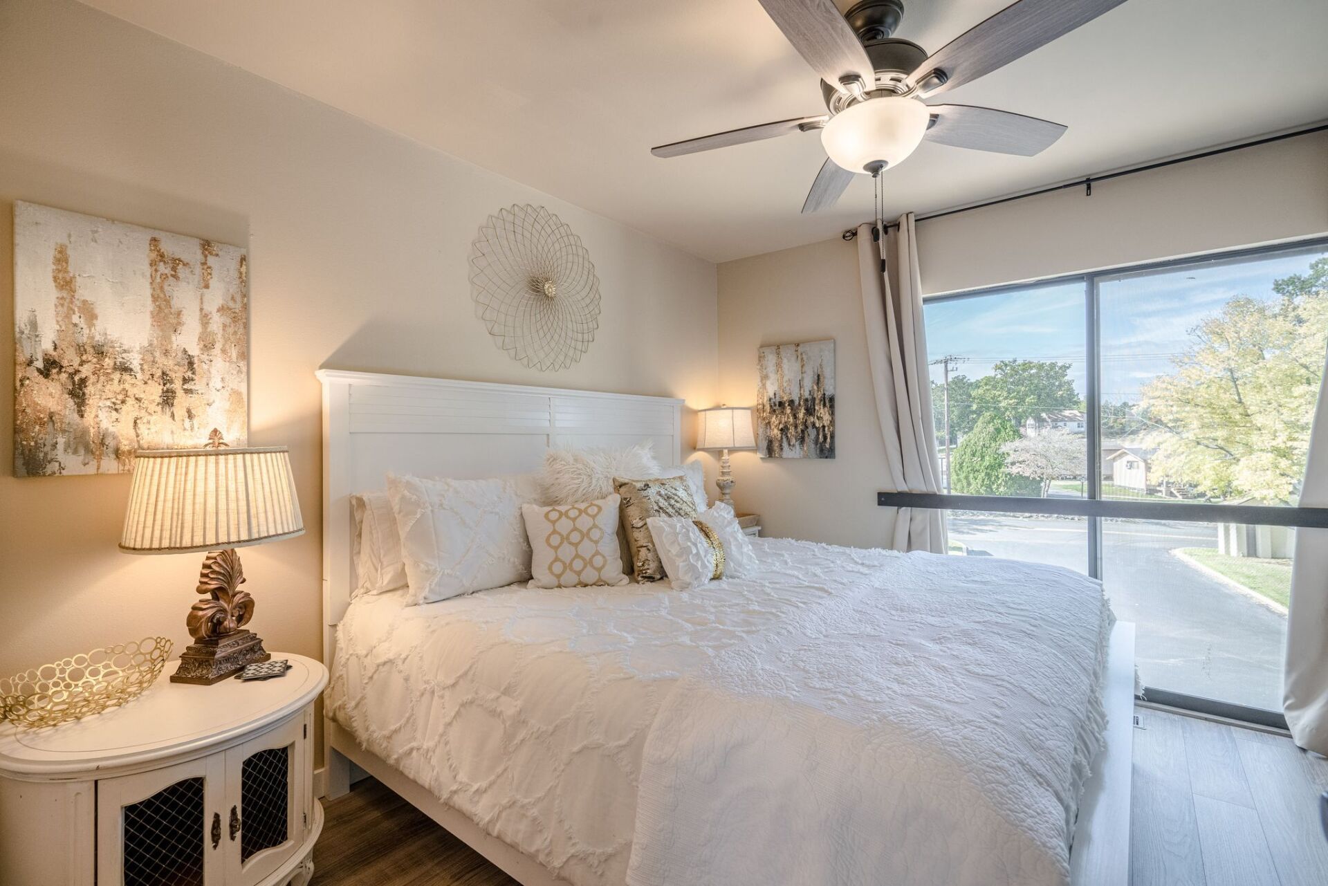 A bedroom with a large bed and a ceiling fan.