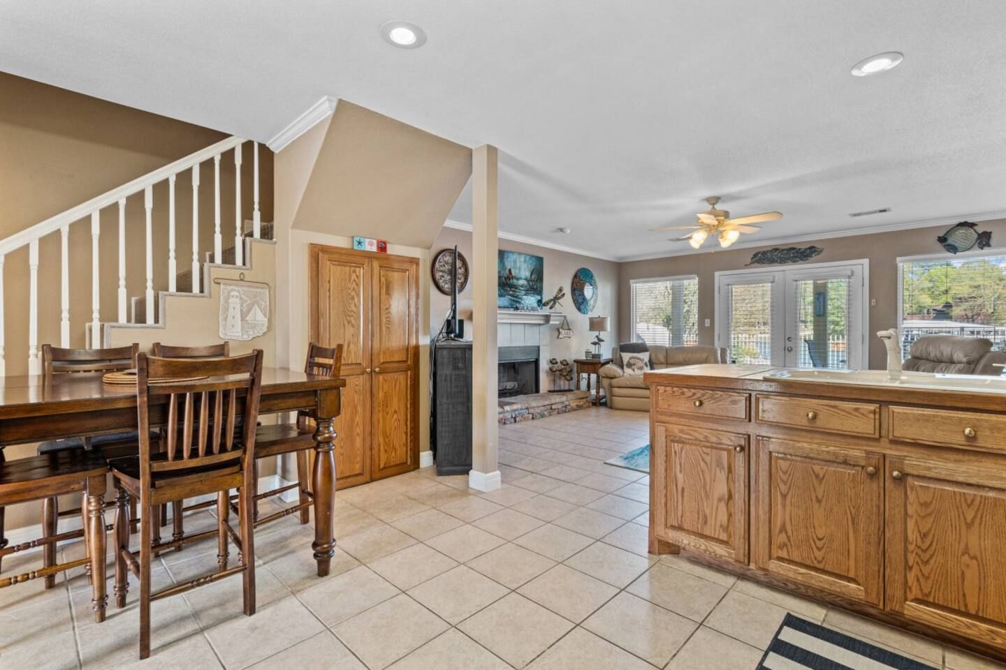 A kitchen with a table and chairs and a staircase leading to the living room.