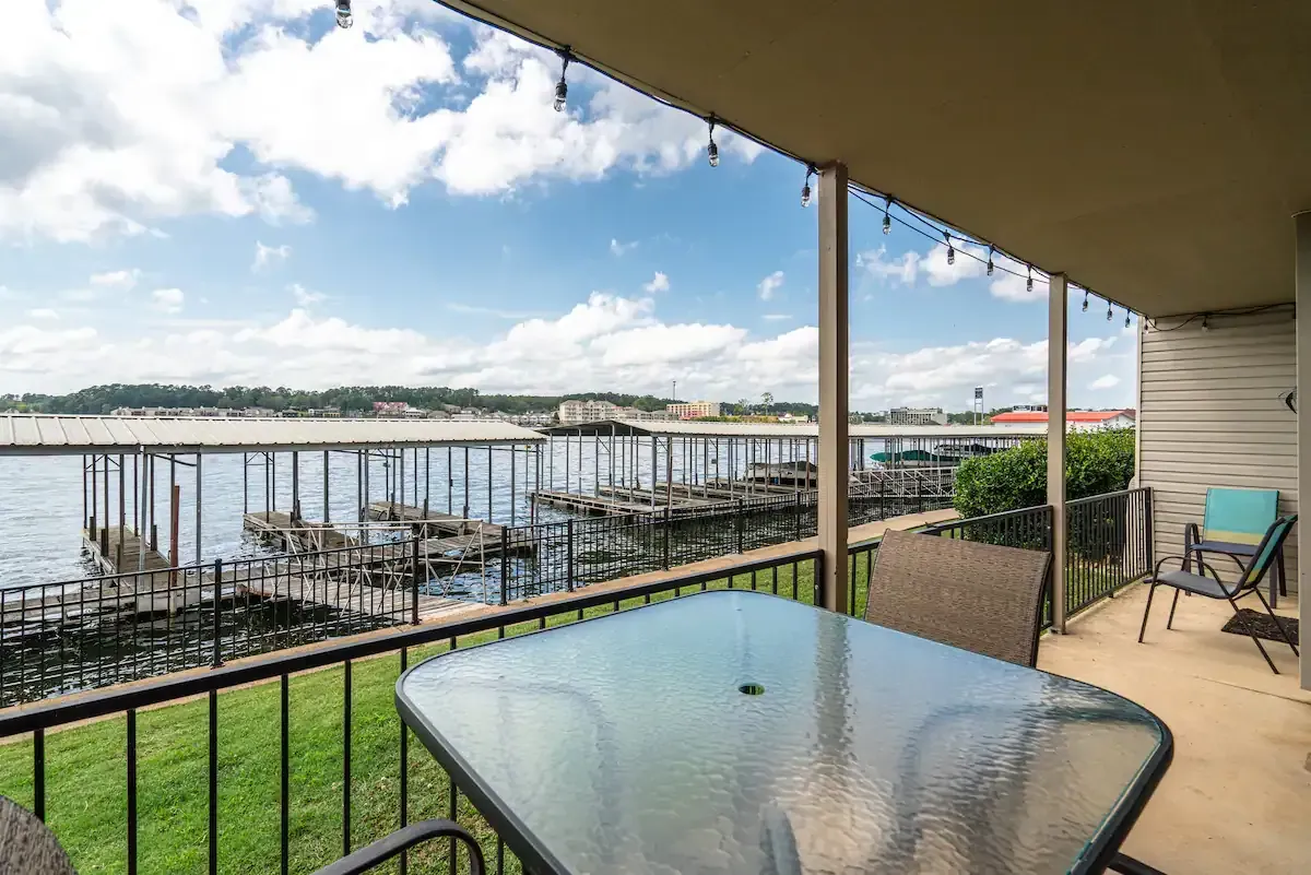 A balcony with a table and chairs overlooking a body of water.