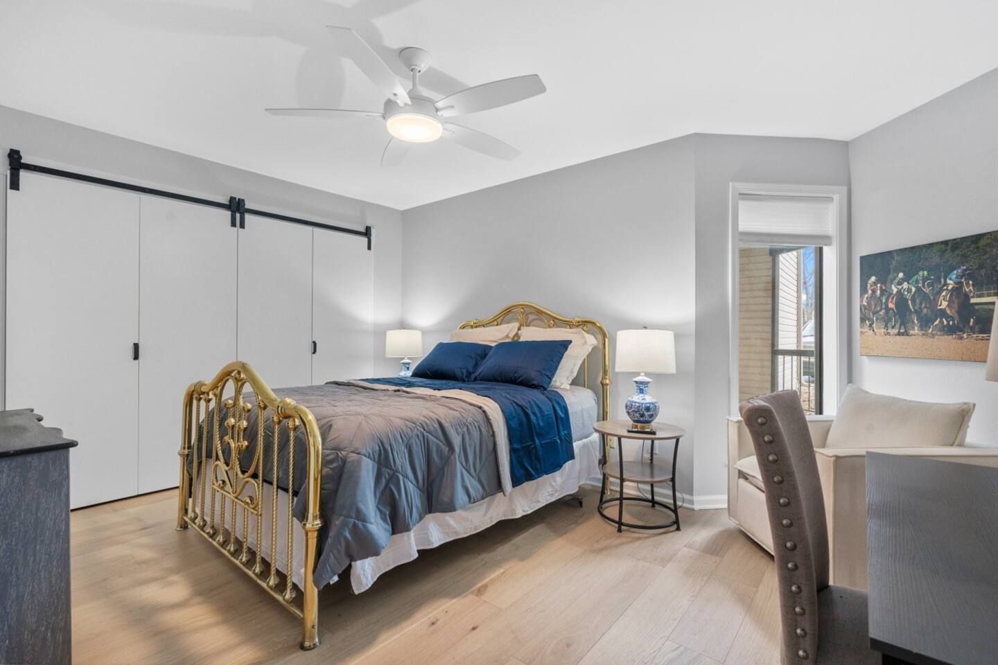 A bedroom with a large bed and a ceiling fan.