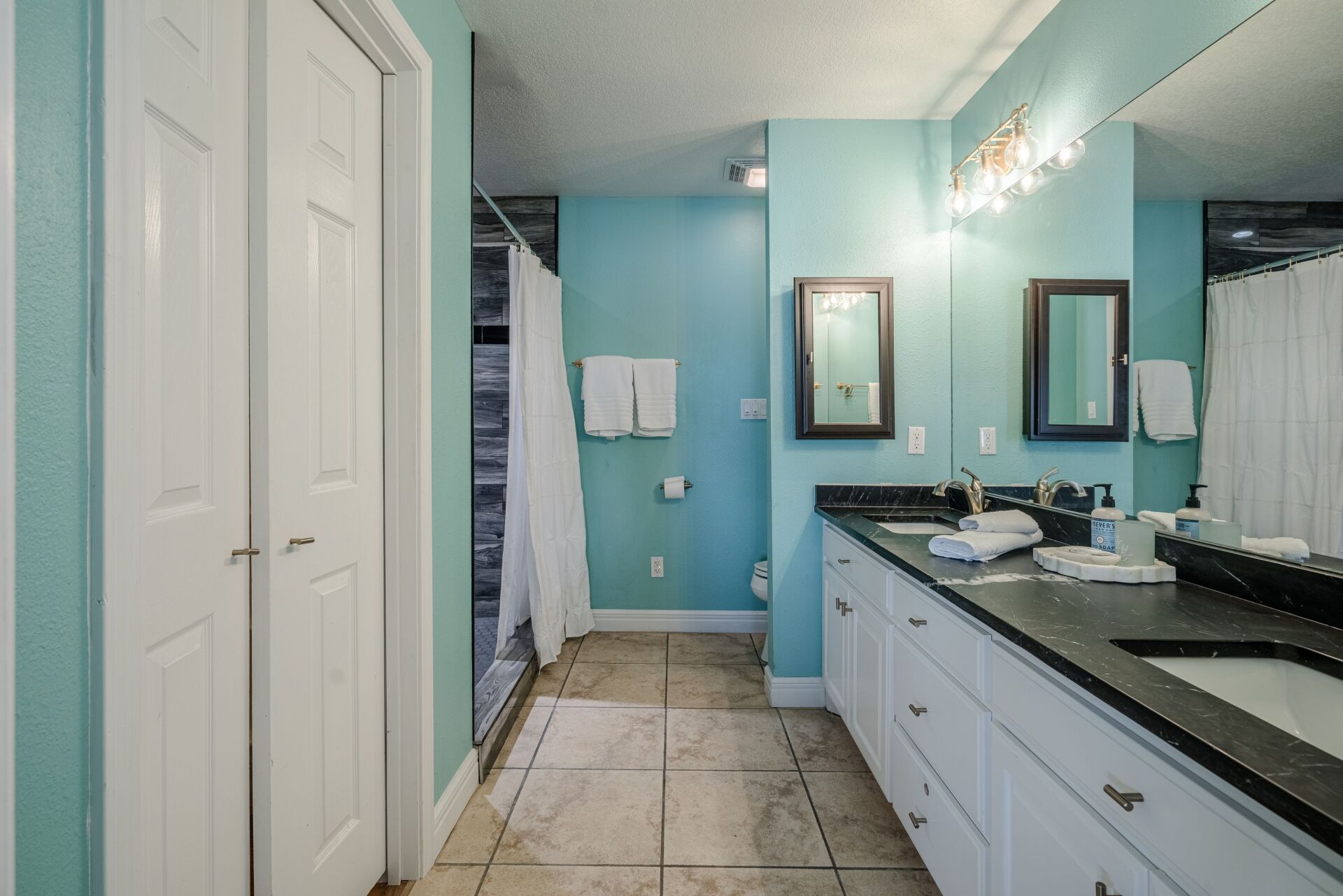 A bathroom with two sinks and a large mirror.